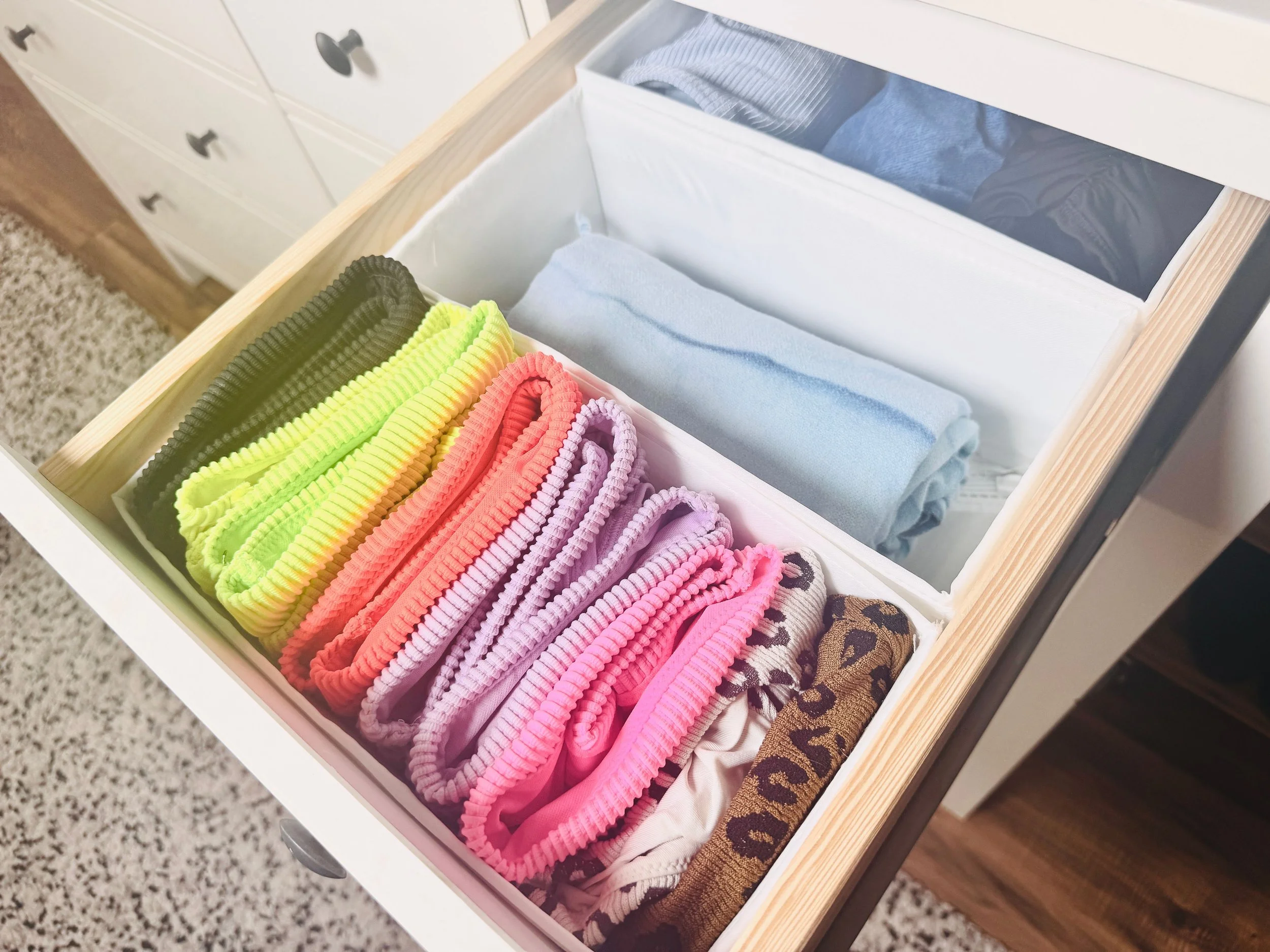 Clean and accessible drawer organization featuring neatly folded swimsuits, beachwear, and a coordinating swim towel for a Park City, Utah home.