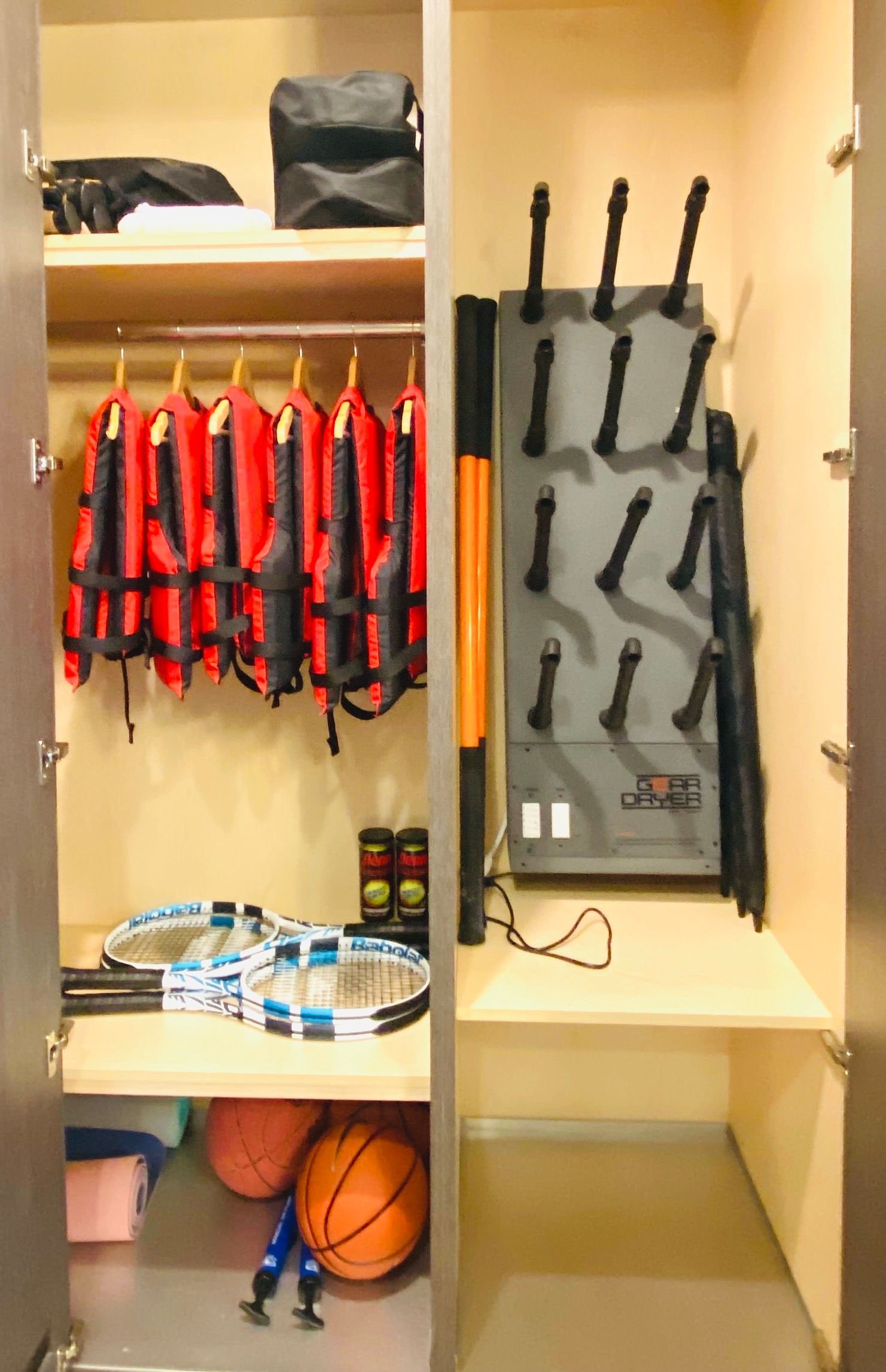 Park City activity closet organization featuring custom storage for tennis rackets, life jackets, basketballs, a ski boot dryer, and snowshoes.