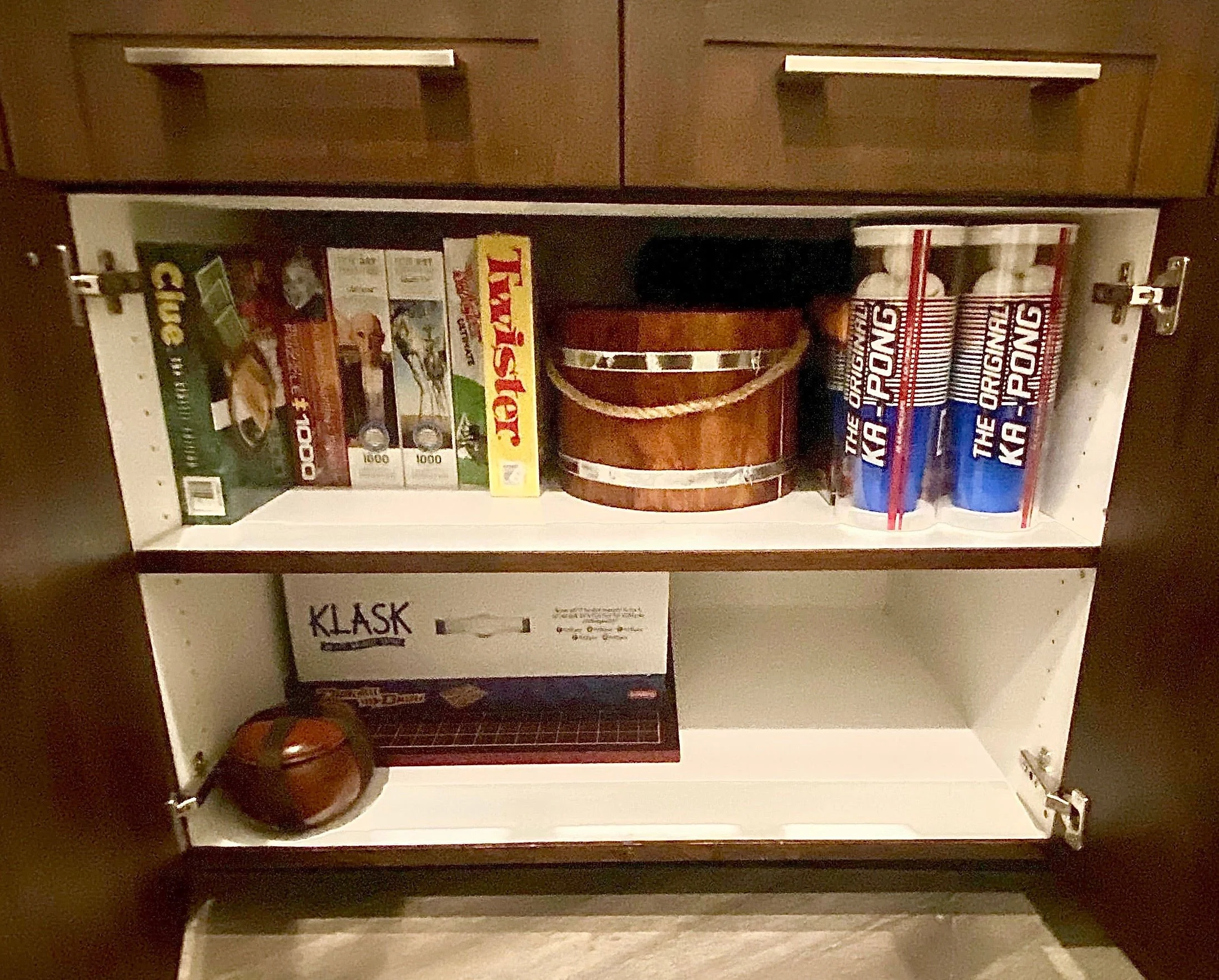 Neatly organized family game cabinet featuring categorized board games, puzzles, and activity boxes in Park City, Utah.