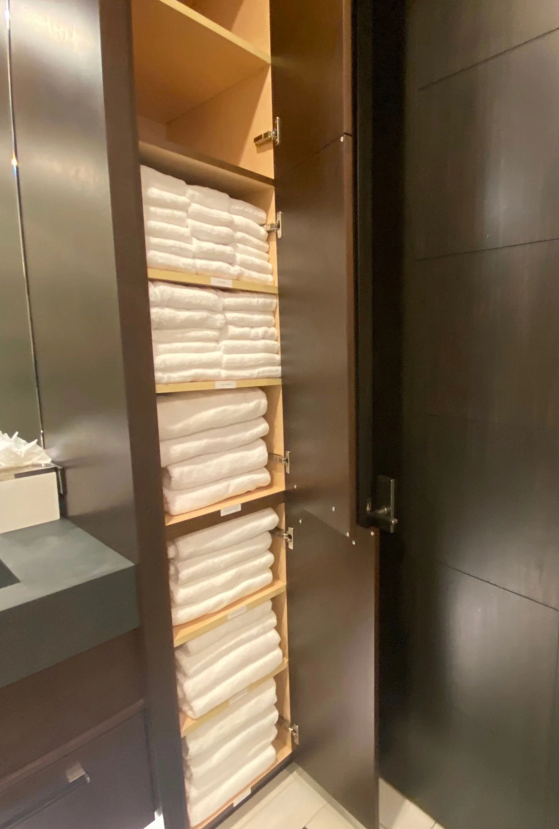 Organized pool house cabana cabinet featuring neatly folded and stacked resort-style swim towels in Park City, Utah.