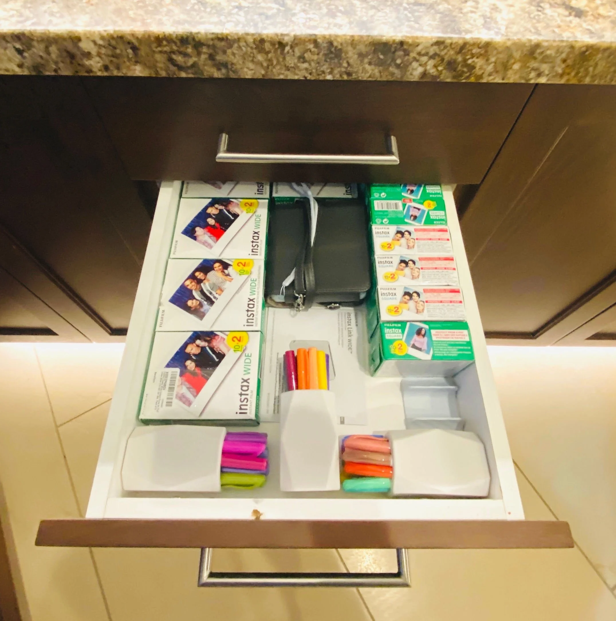 Creative photography drawer organization featuring vintage cameras, Polaroid film packs, and designated storage for markers in Park City, Utah.