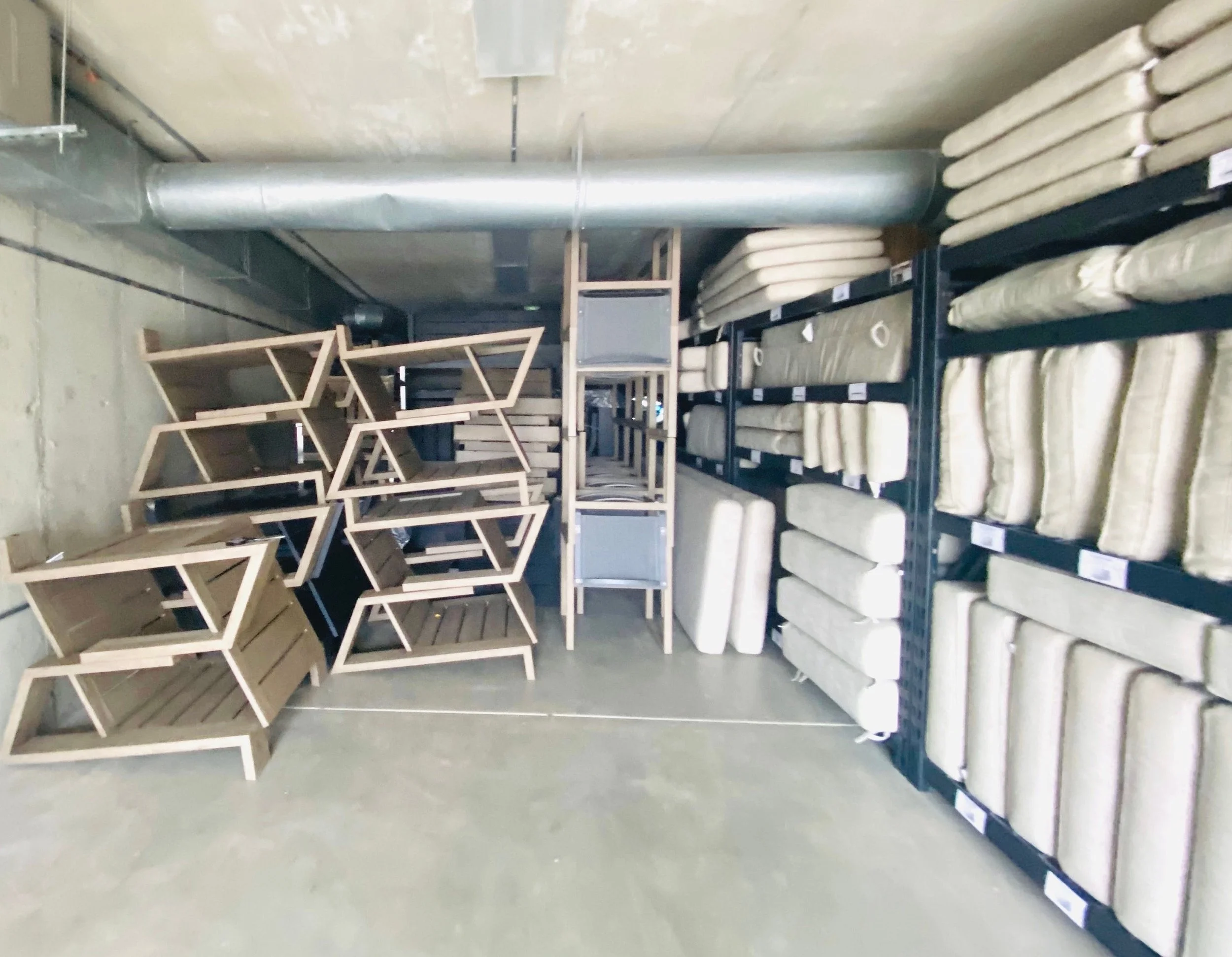 Super organized garage storage featuring neatly stacked outdoor patio furniture, seasonal tables, and coordinated backyard cushions and pillows in Park City, Utah.