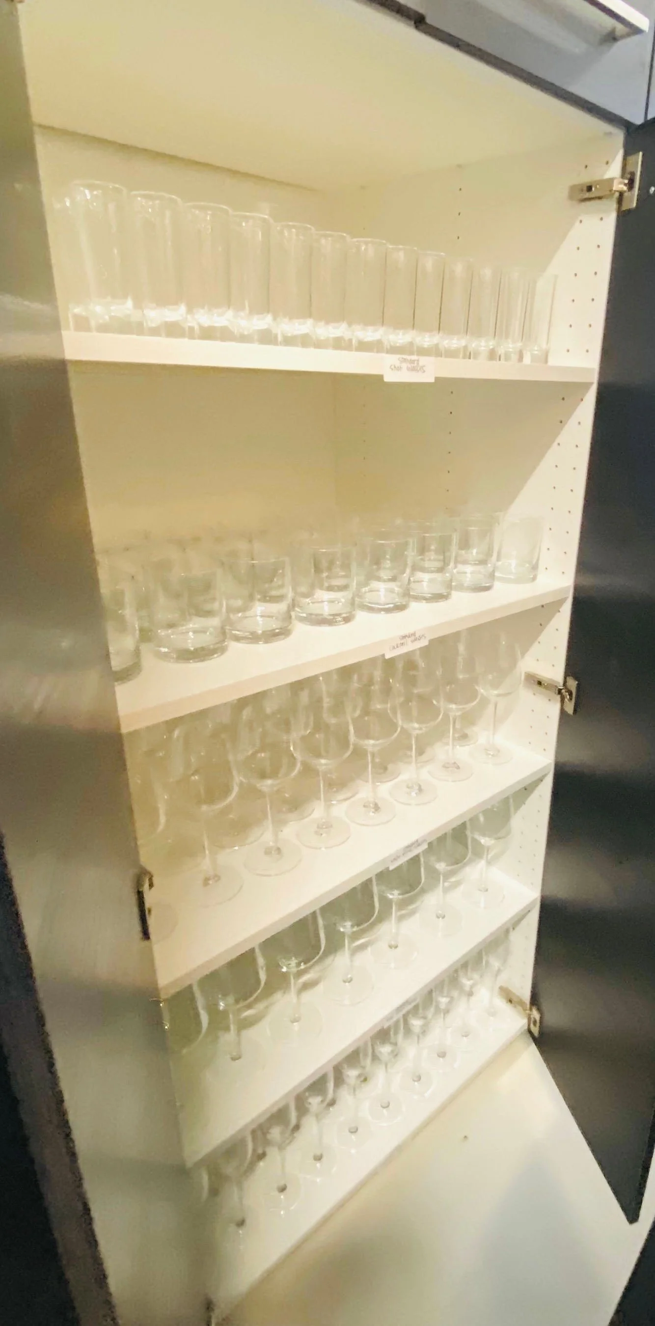 Large glass display cabinet perfectly organized with a wide variety of elegant entertaining and party glassware in Park City, Utah.