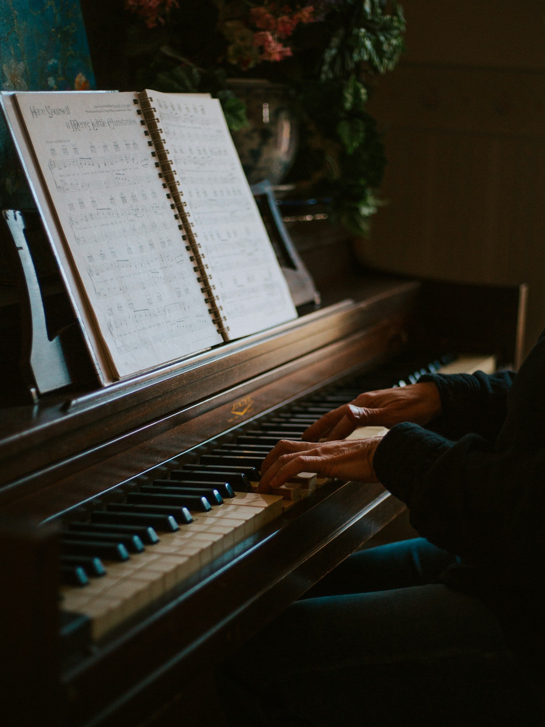 A man playing on a old grand piano