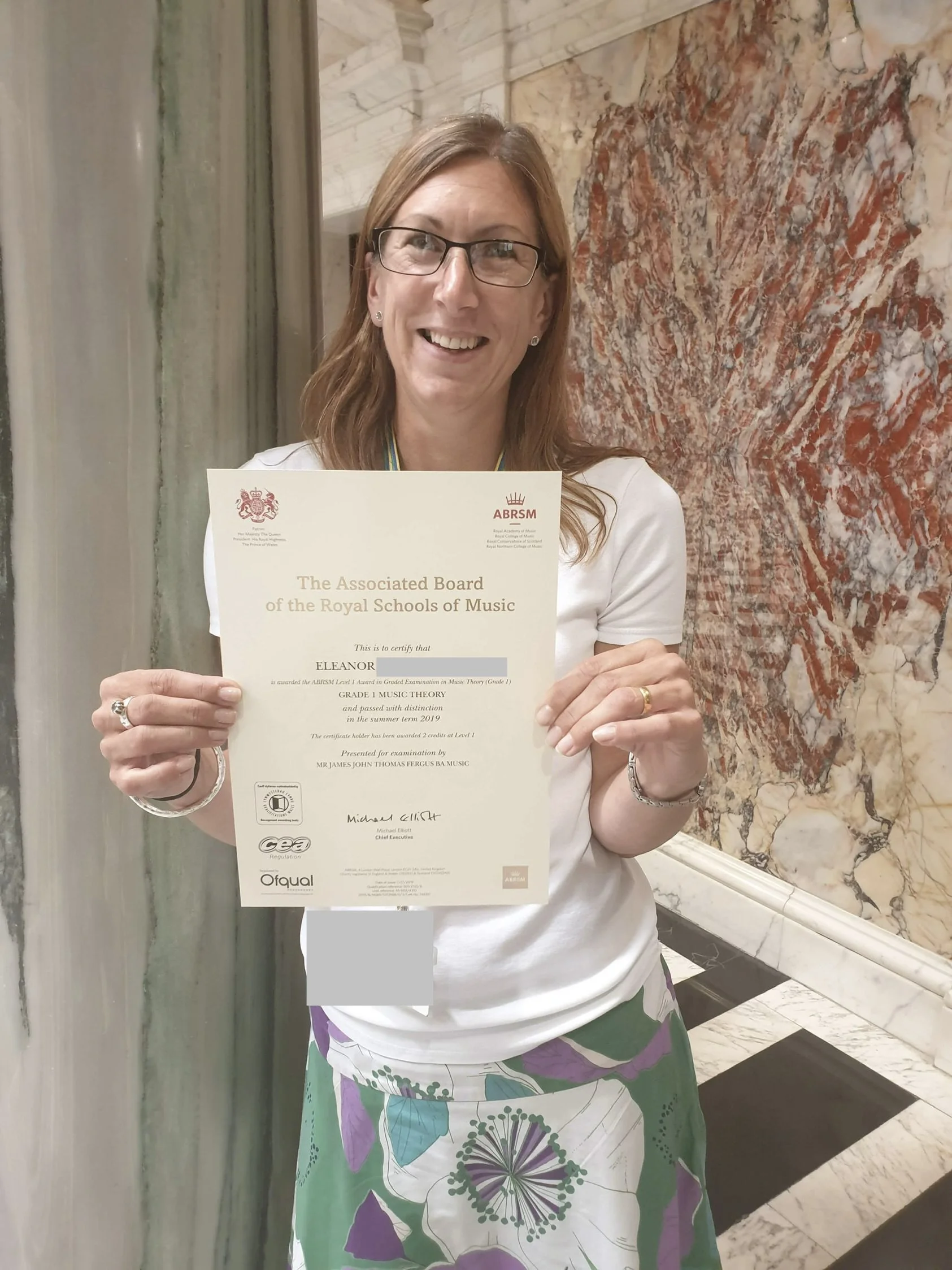 A woman proudly showing her music certificate