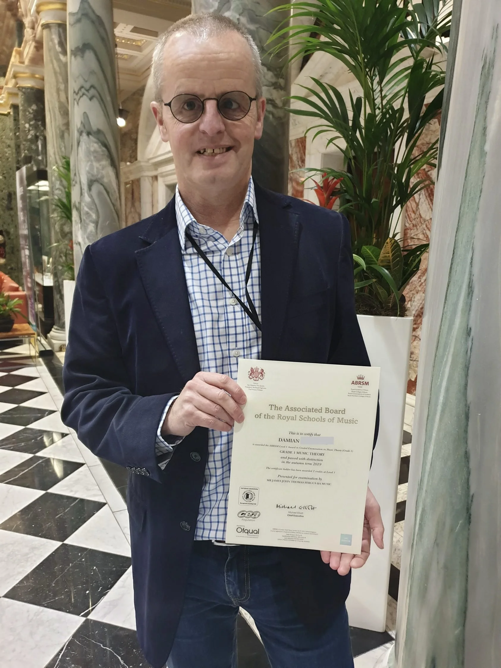 A man proudly holding his Music certificate 