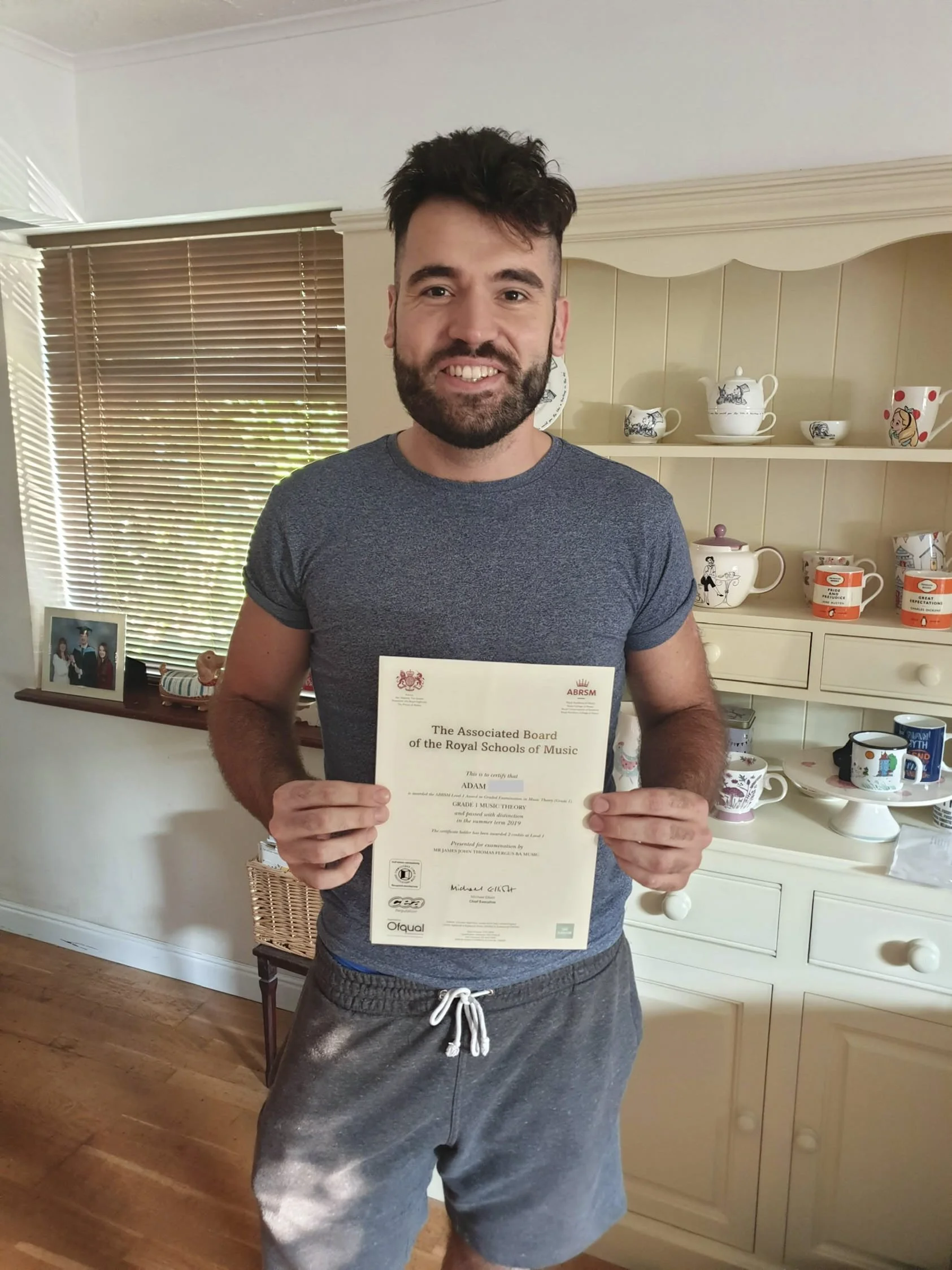 A man proudly holding his Music certificate 
