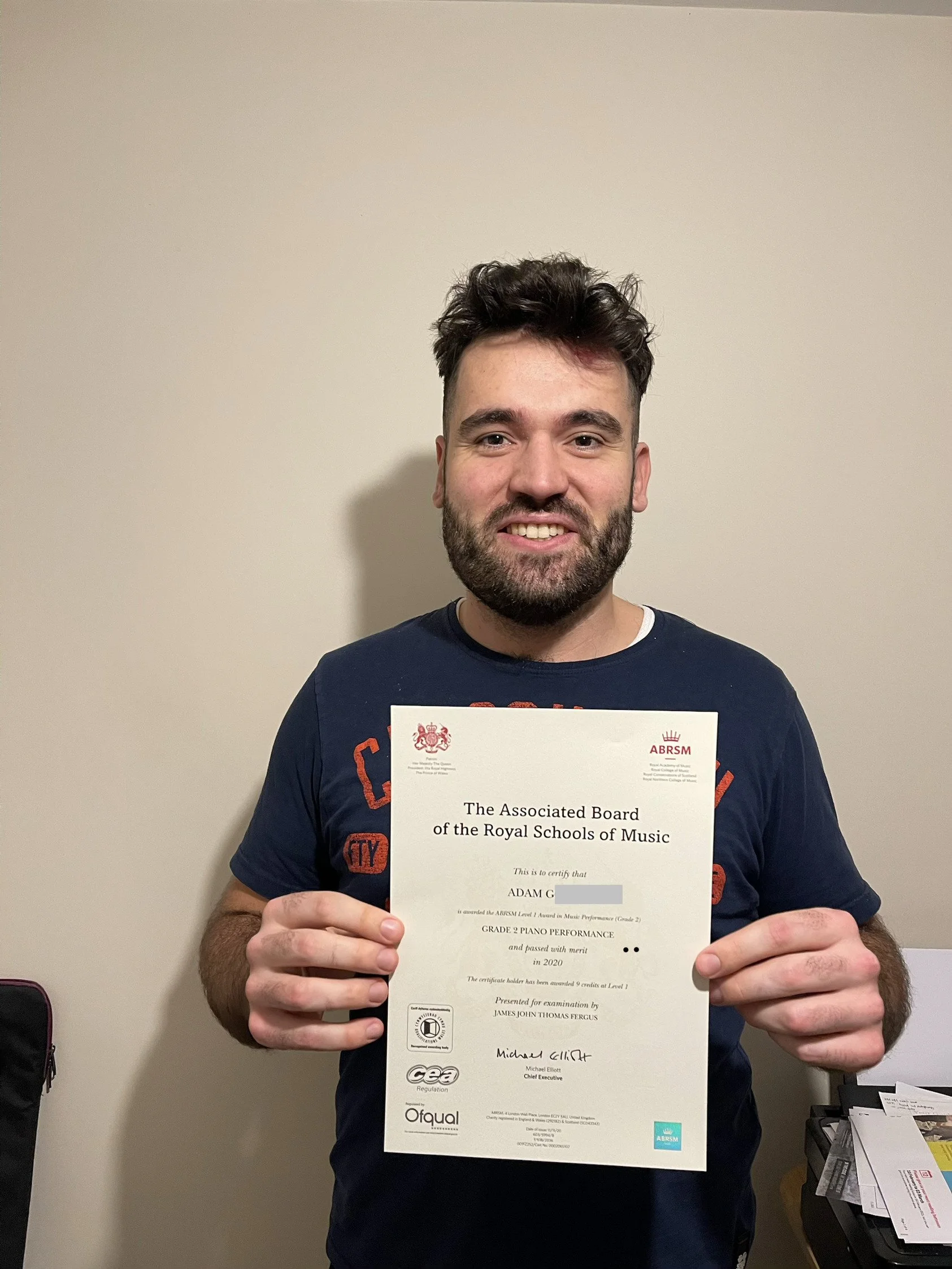 A man proudly holding his Music certificate 