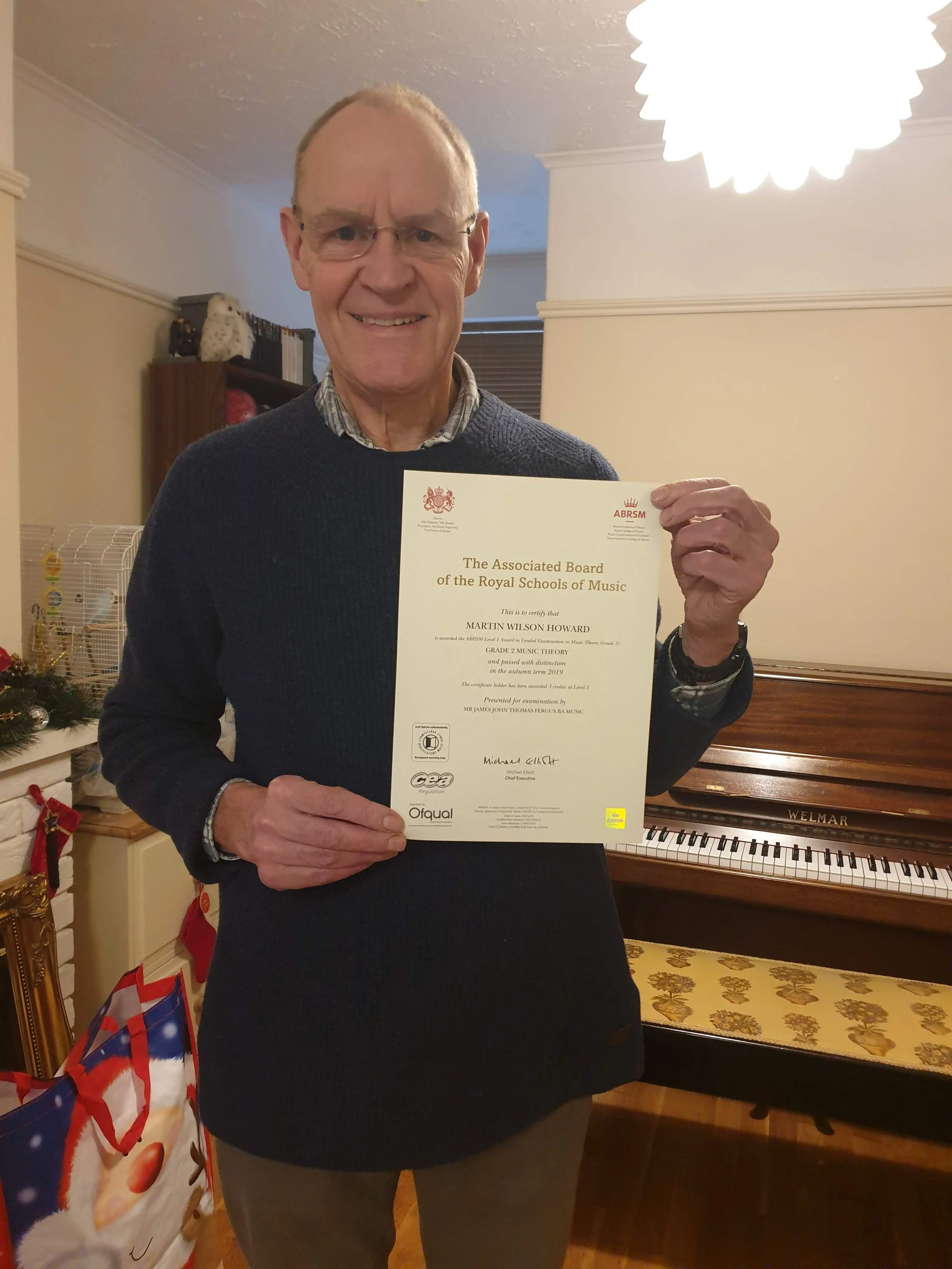 A man proudly holding his Music certificate 