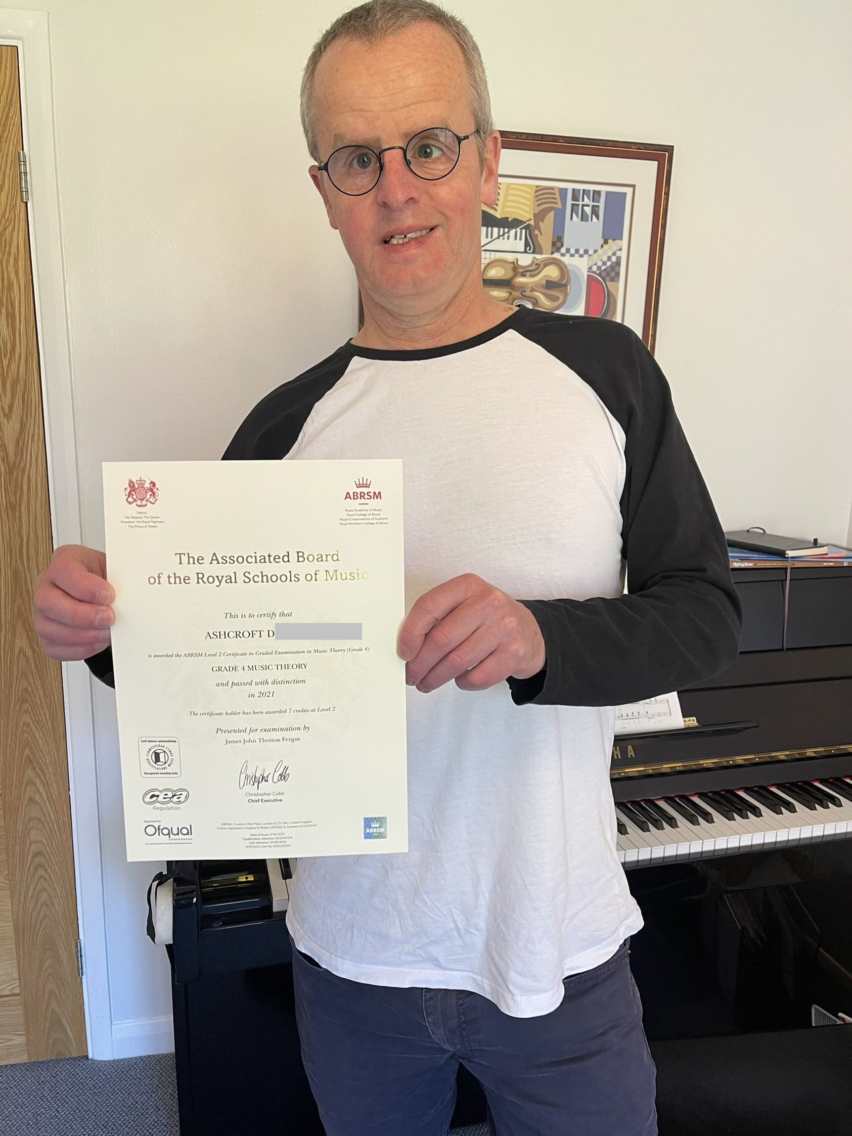 A man proudly holding his Music certificate 