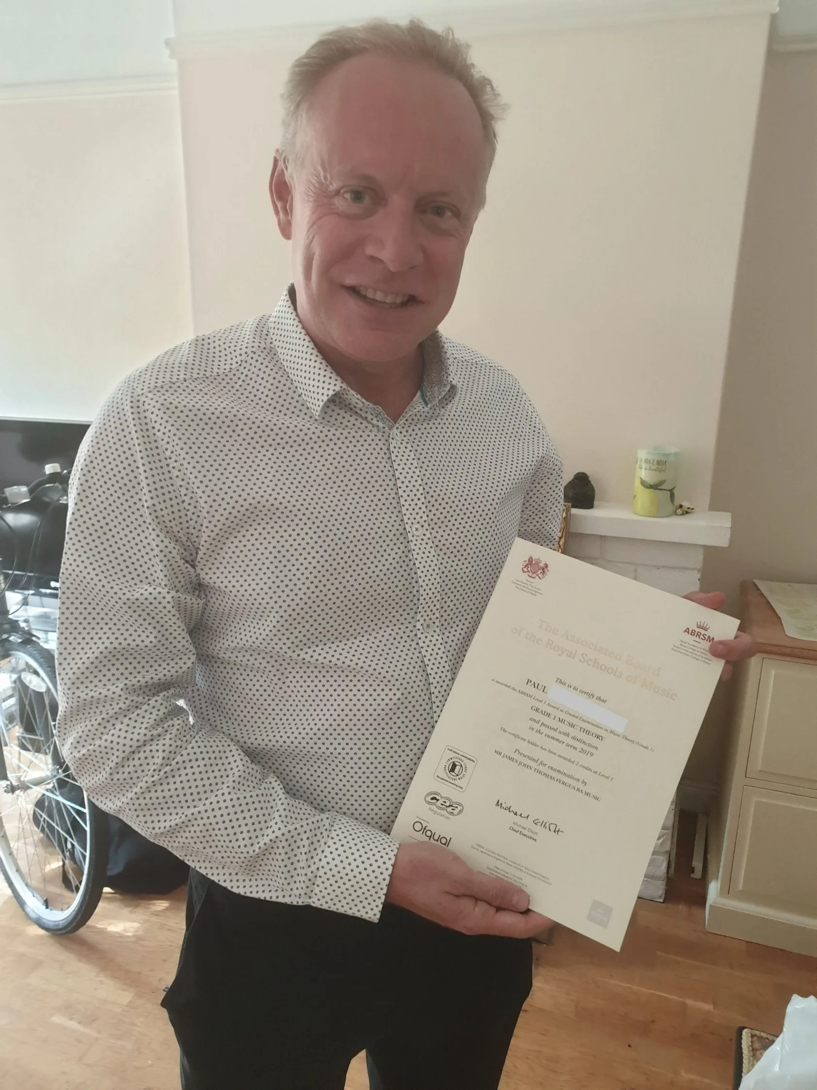A man proudly holding his Music certificate 