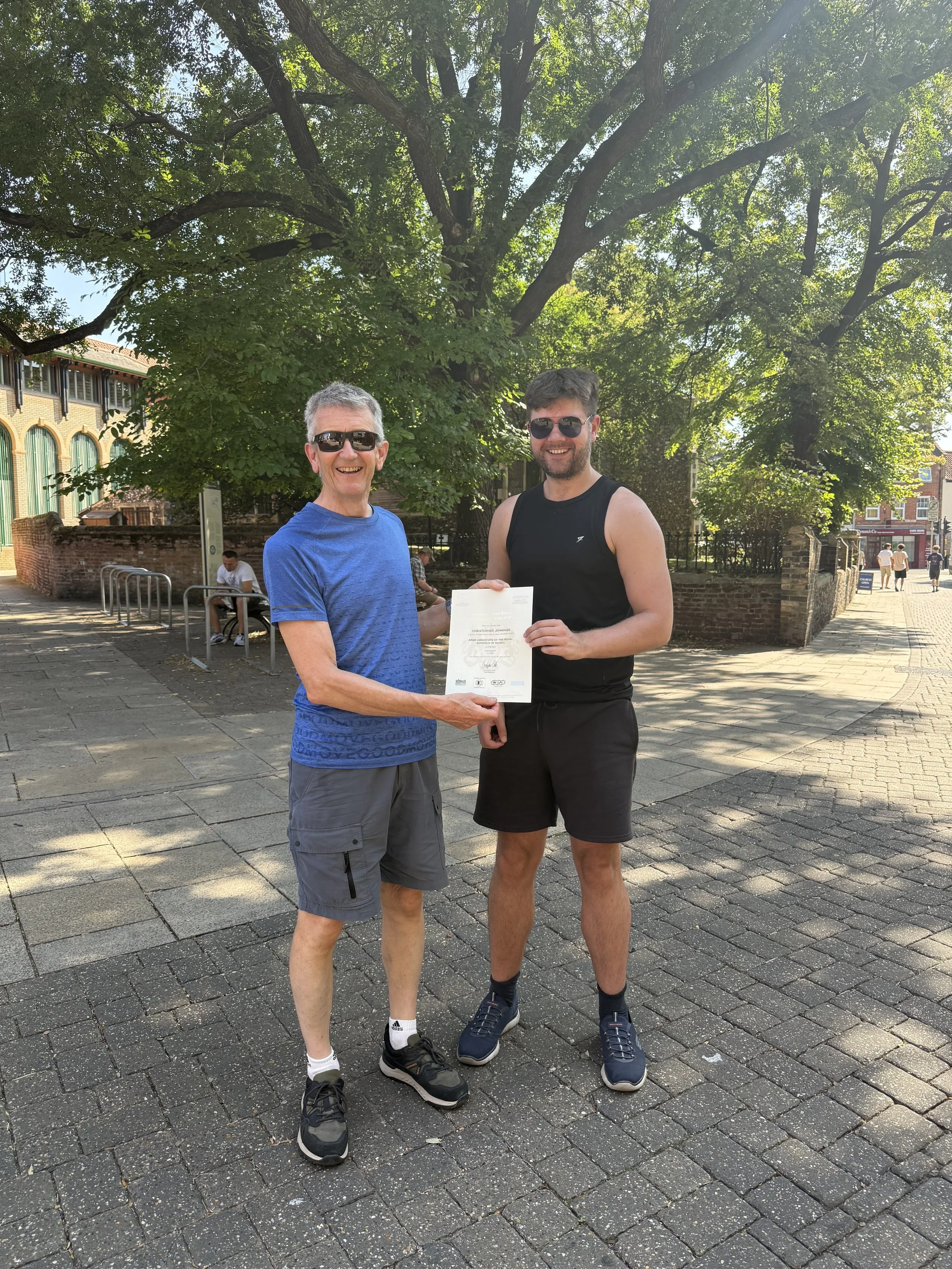 James and his student proudly holding his earned certificate
