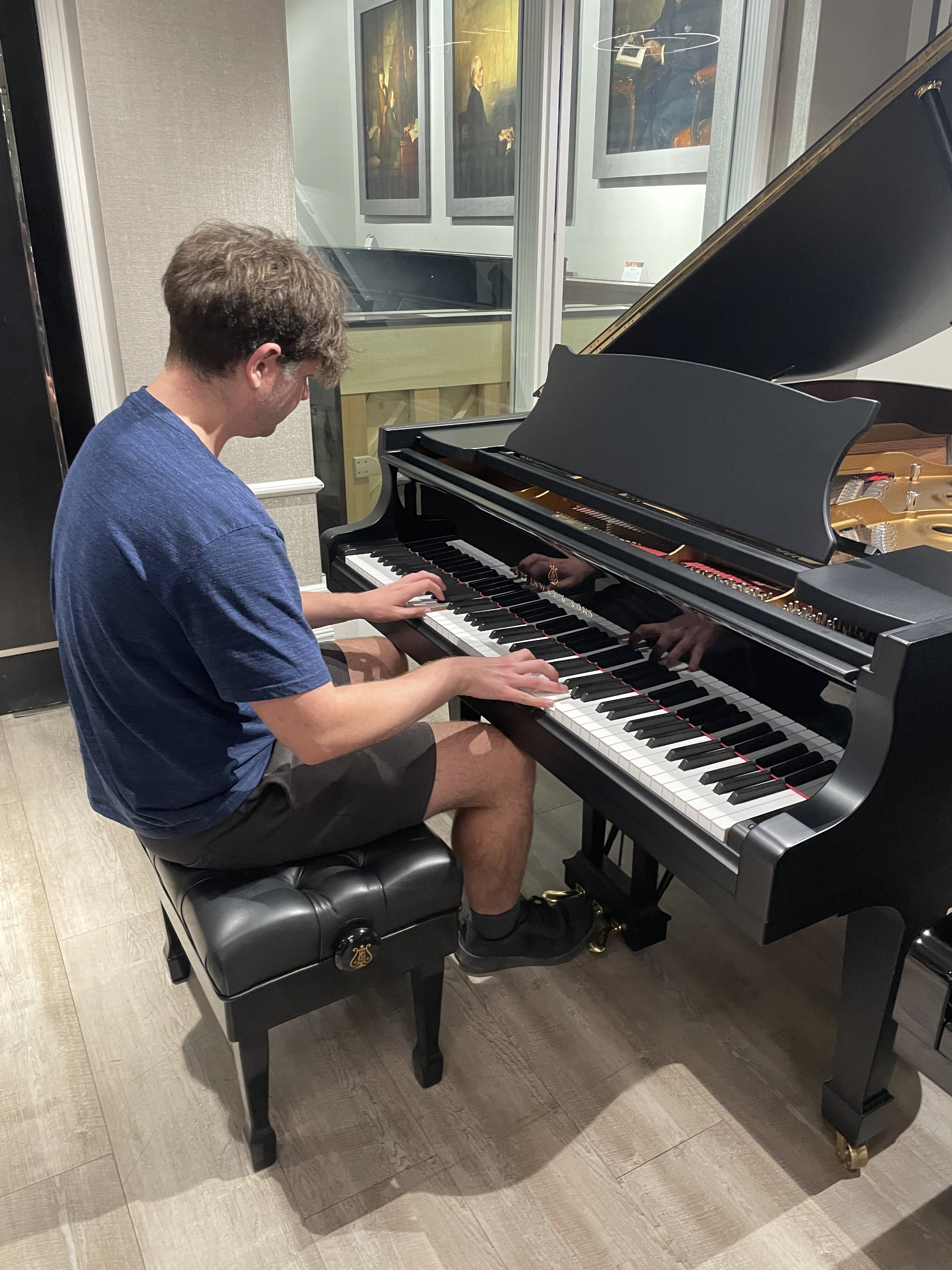 James playing on a black Steinway Grand Piano