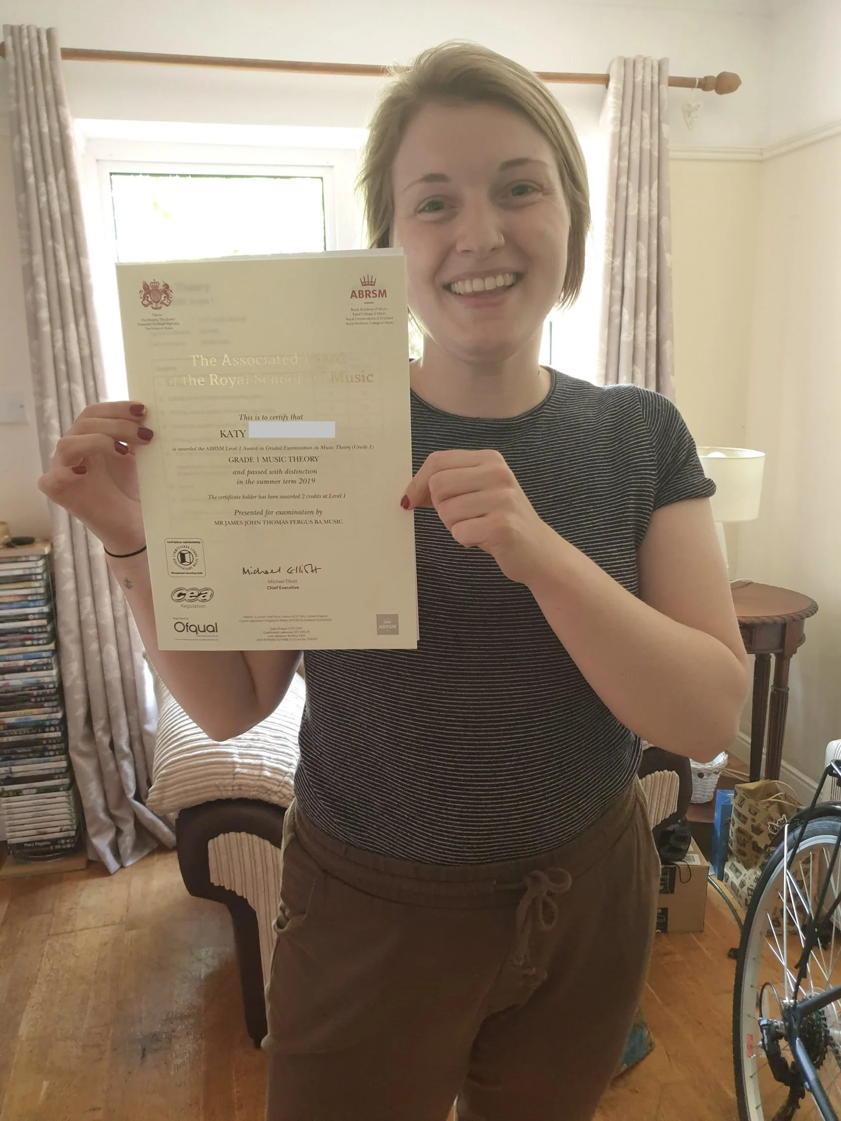 A woman proudly showing her music certificate
