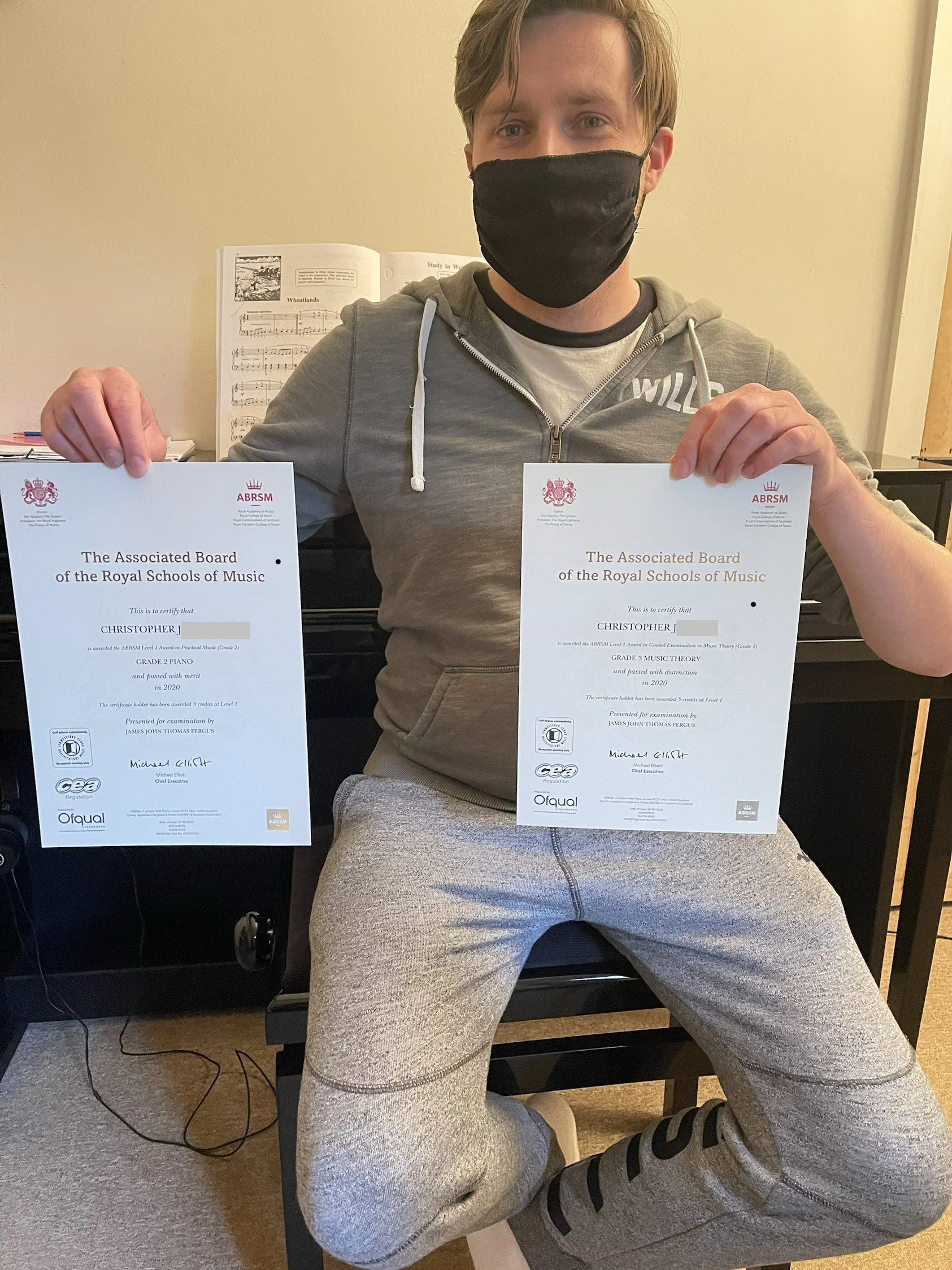 A man proudly holding his Music certificates