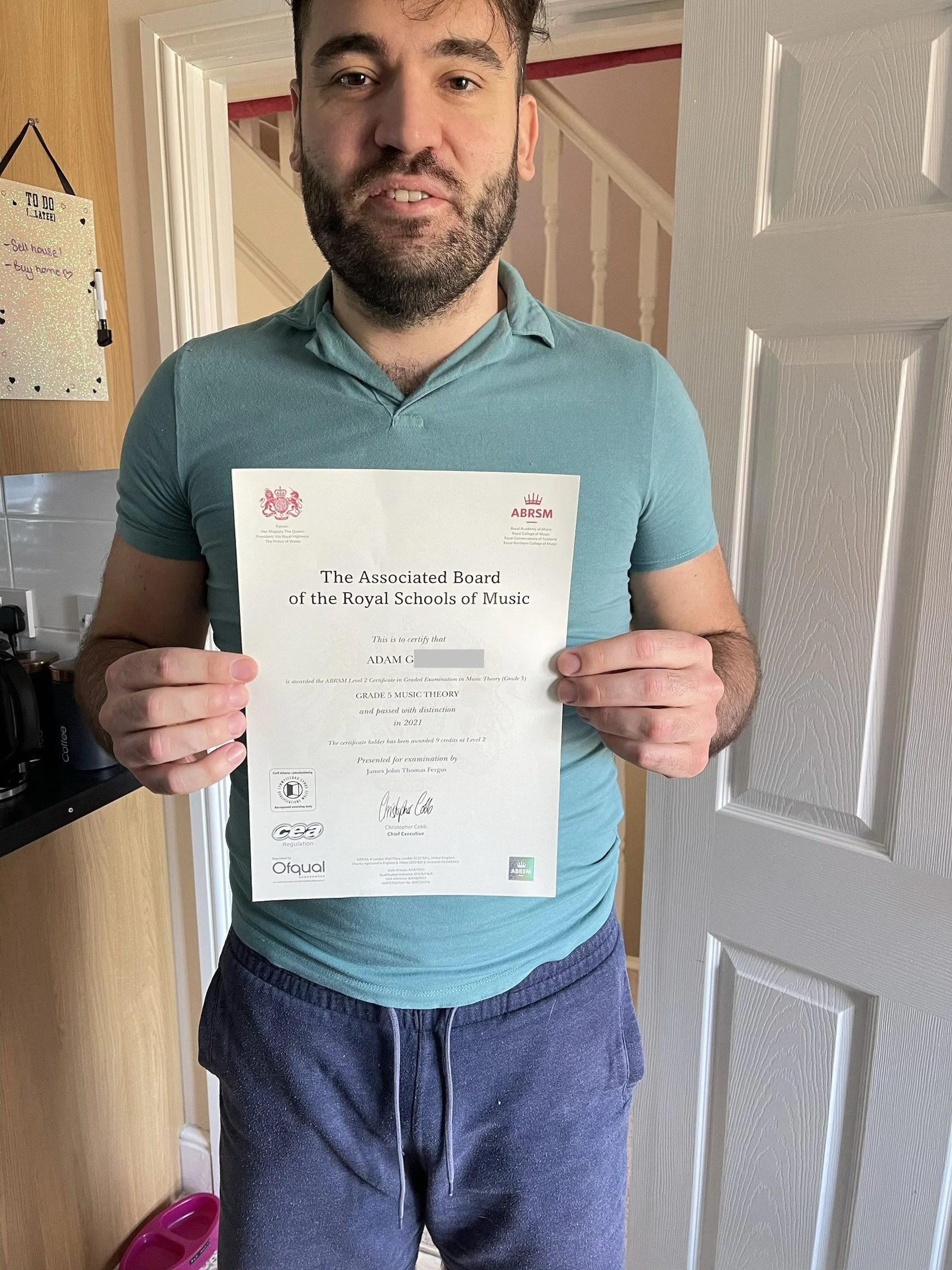 A man proudly holding his Music certificate 