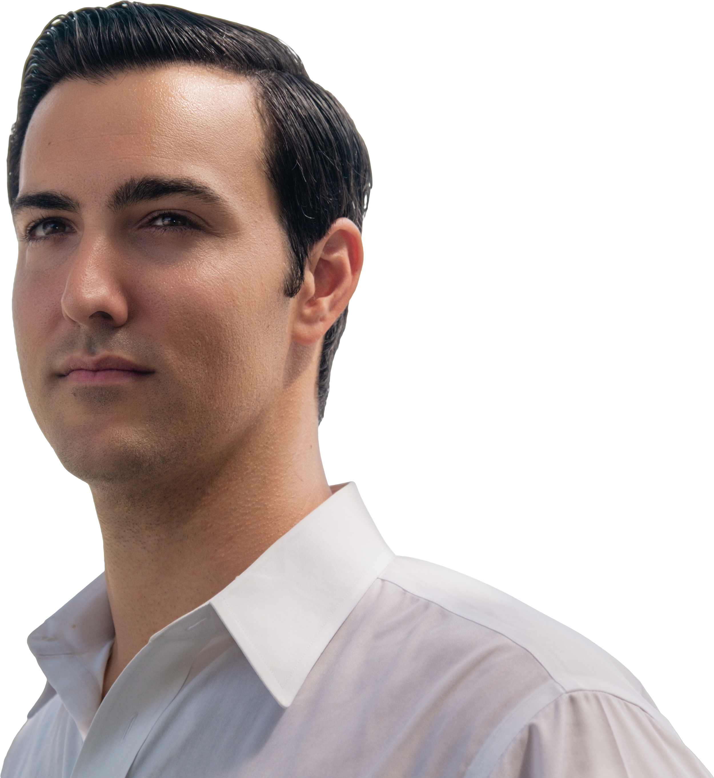 Close-up of a young man with dark, slicked-back hair, wearing a white shirt with a collar. He has clear, smooth skin and dark eyebrows. The background appears to be a neutral or light setting.
