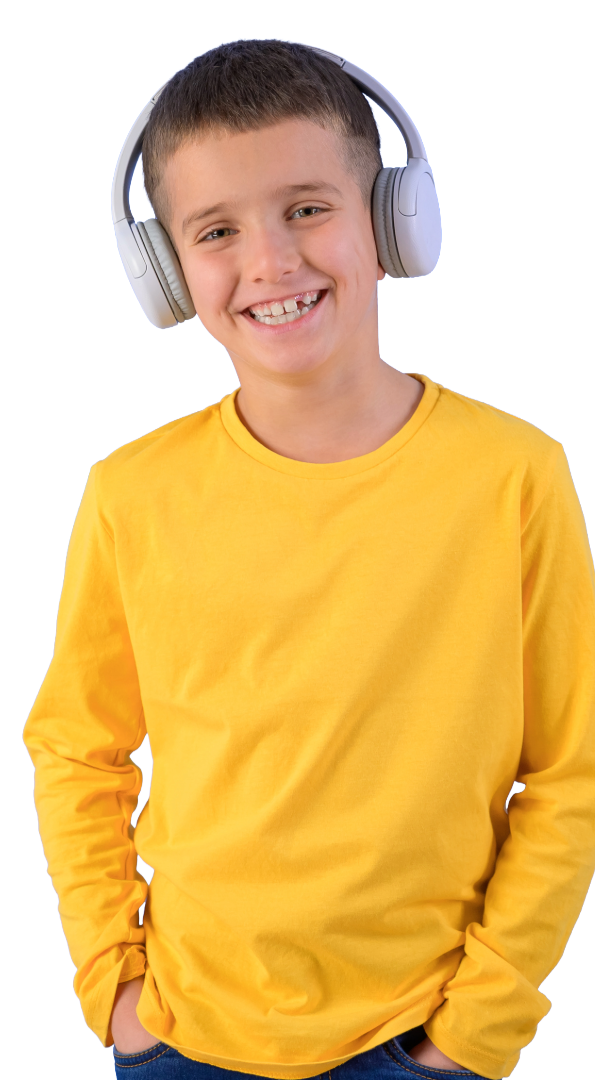 A smiling boy wearing a yellow long-sleeve shirt and large gray over-ear headphones.