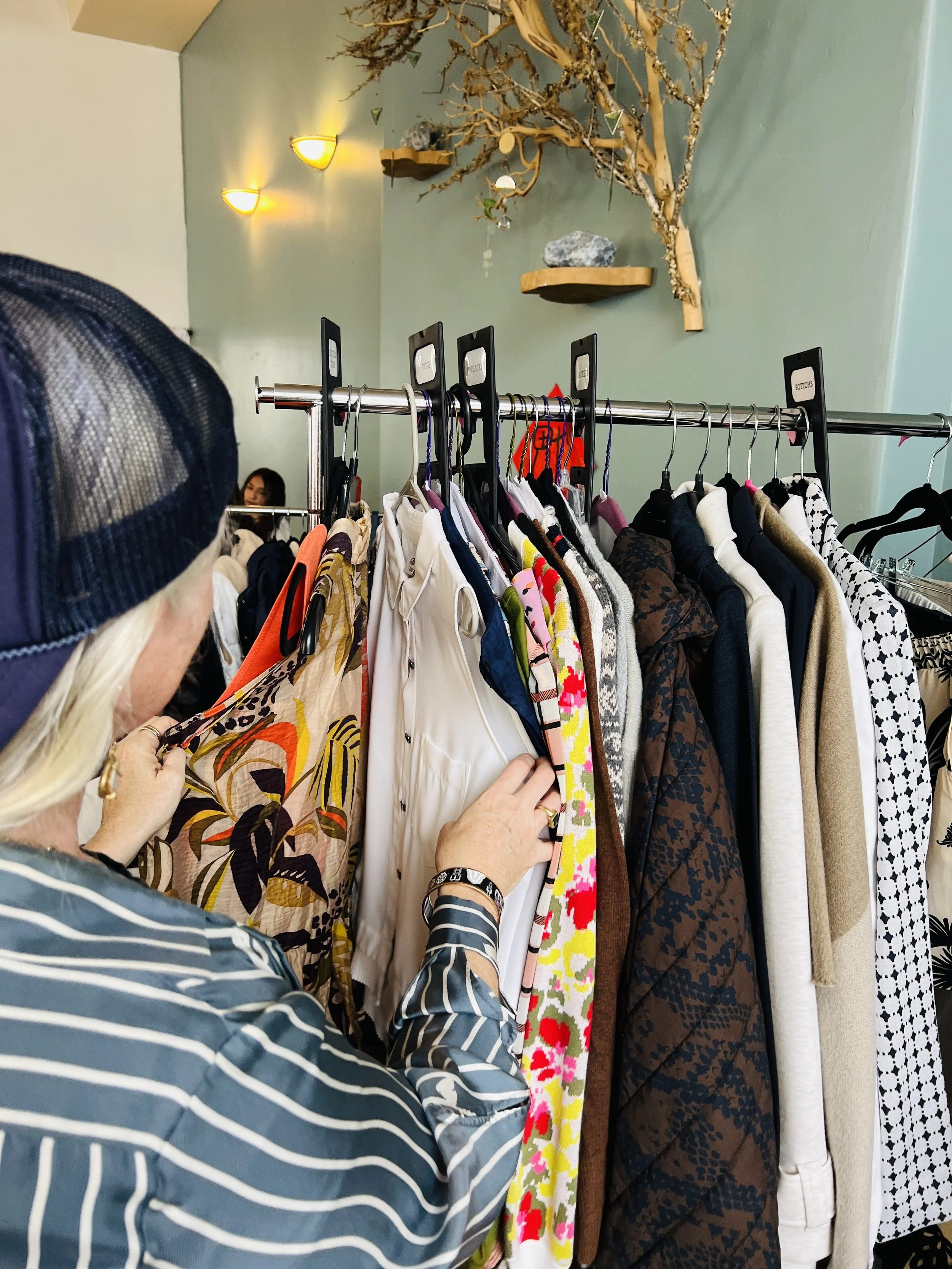 Fashionable shopper browses a rack of second hand finds