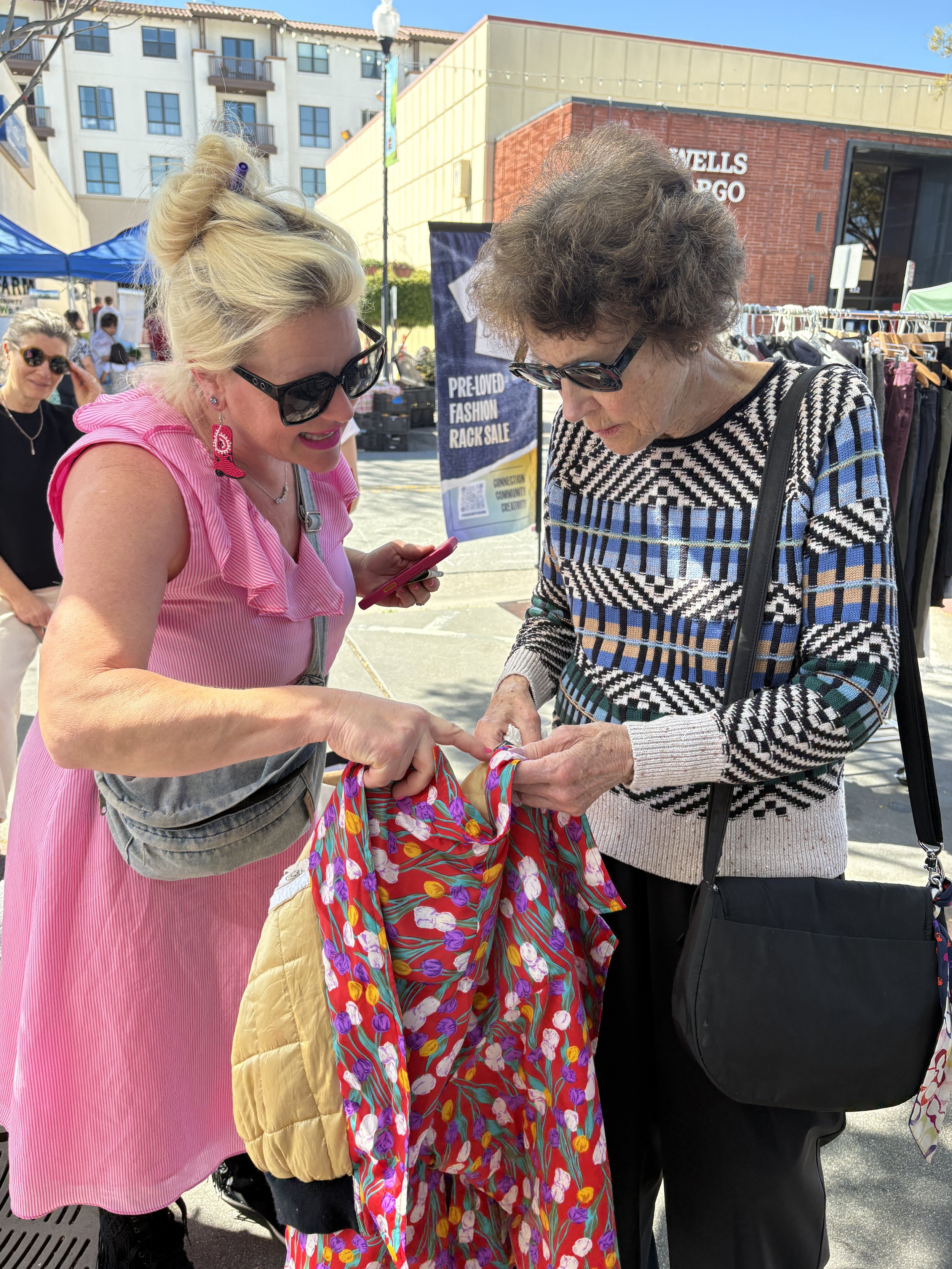 Popup vendor and shopper examine a scarf