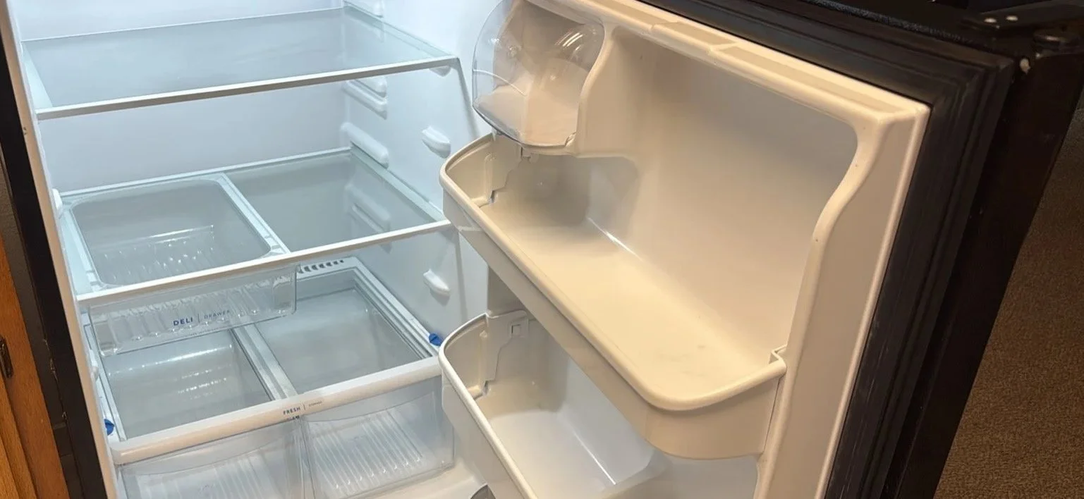 Empty refrigerator with glass shelves and door storage compartments.