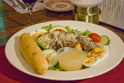 A salad with fresh veggies, and warm bread at George Steak House