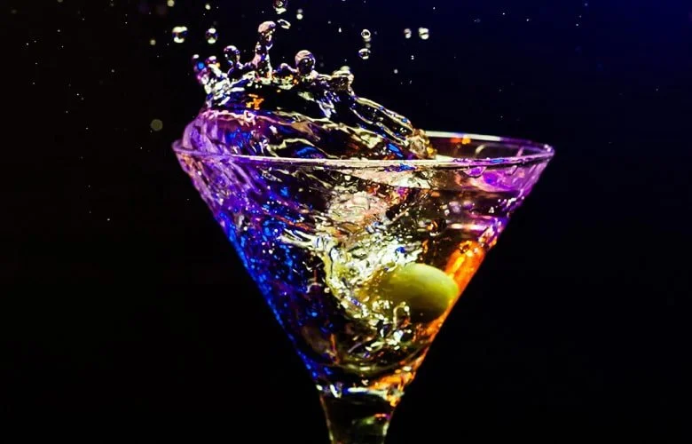 A colorful splash in a martini glass, highlighting the classic cocktail lounge experience at George's.