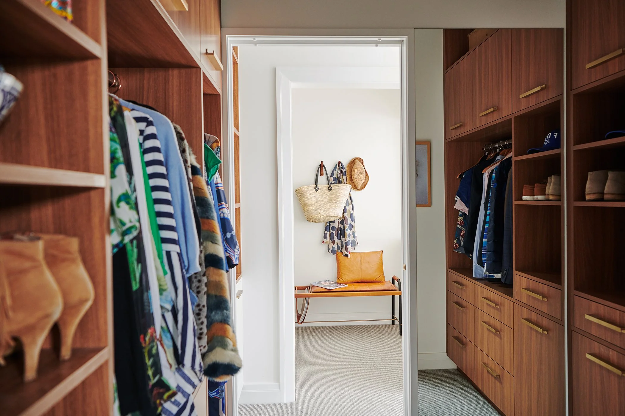 Modern residential interior design featuring a walnut walk-in wardrobe