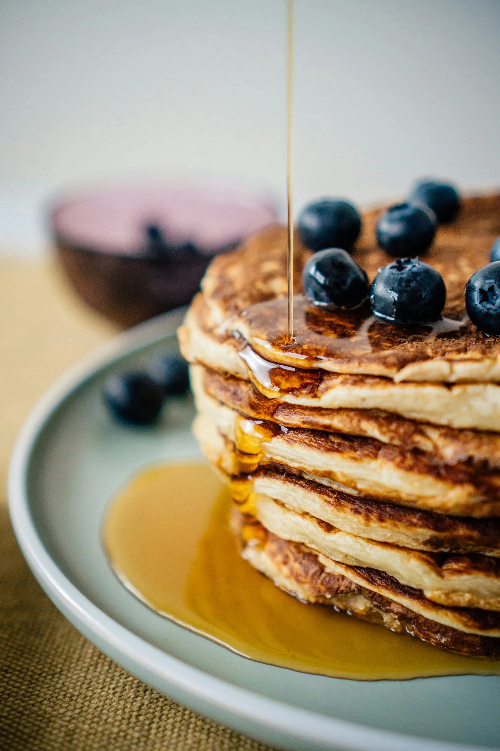 Stack of pancakes with blueberries and maple syrup.