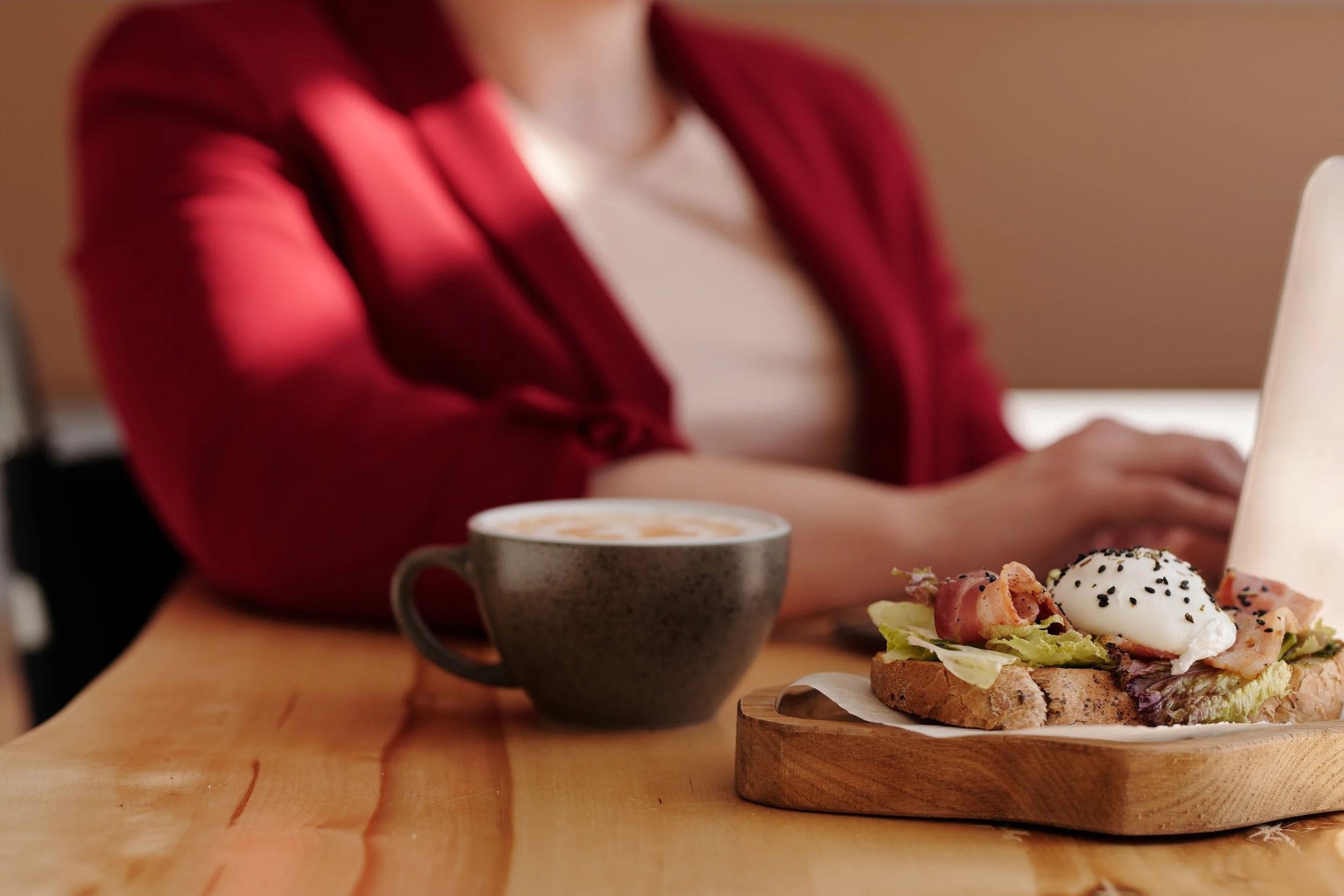 uest enjoying breakfast with coffee at a café table.