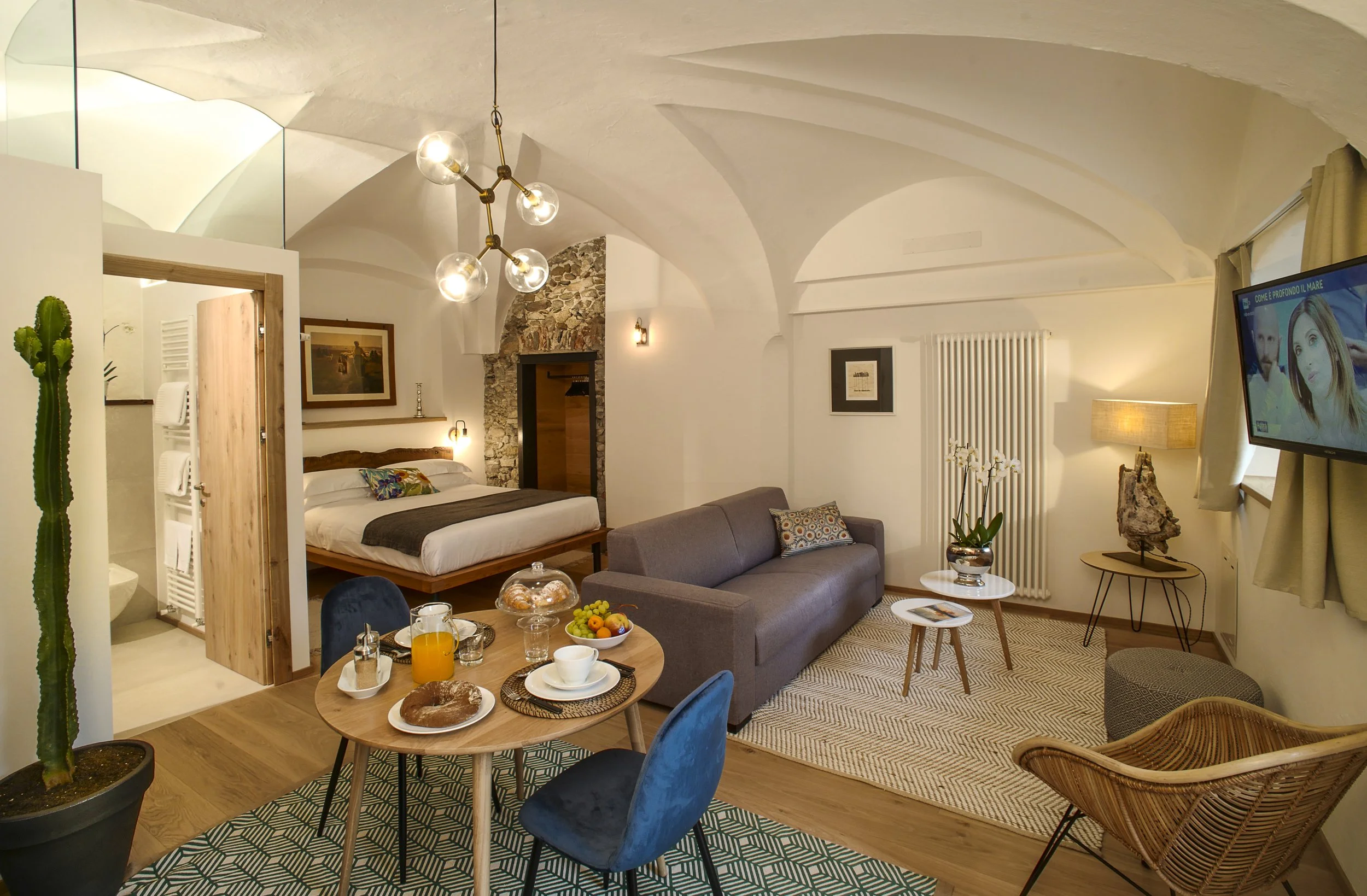 Elegant living area at Caurga Deluxe in Palazzo Giani, featuring historic vaulted ceilings, refined interiors and modern comforts in Chiavenna.