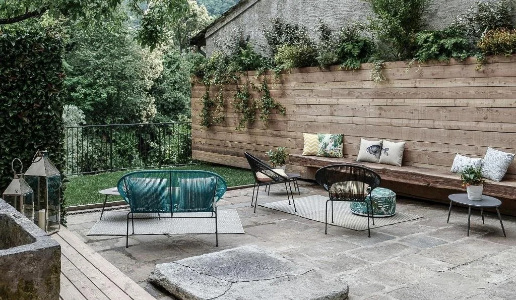 Private garden terrace at Palazzo Giani with elegant outdoor seating, surrounded by greenery in the historic center of Chiavenna.