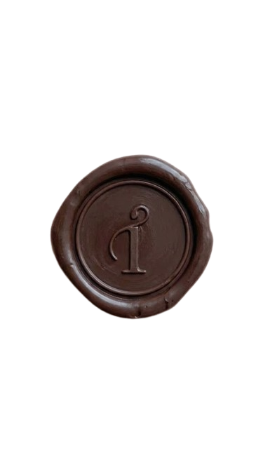 A round chocolate wax seal with Taegan Irving brand mark engraved in the centre.