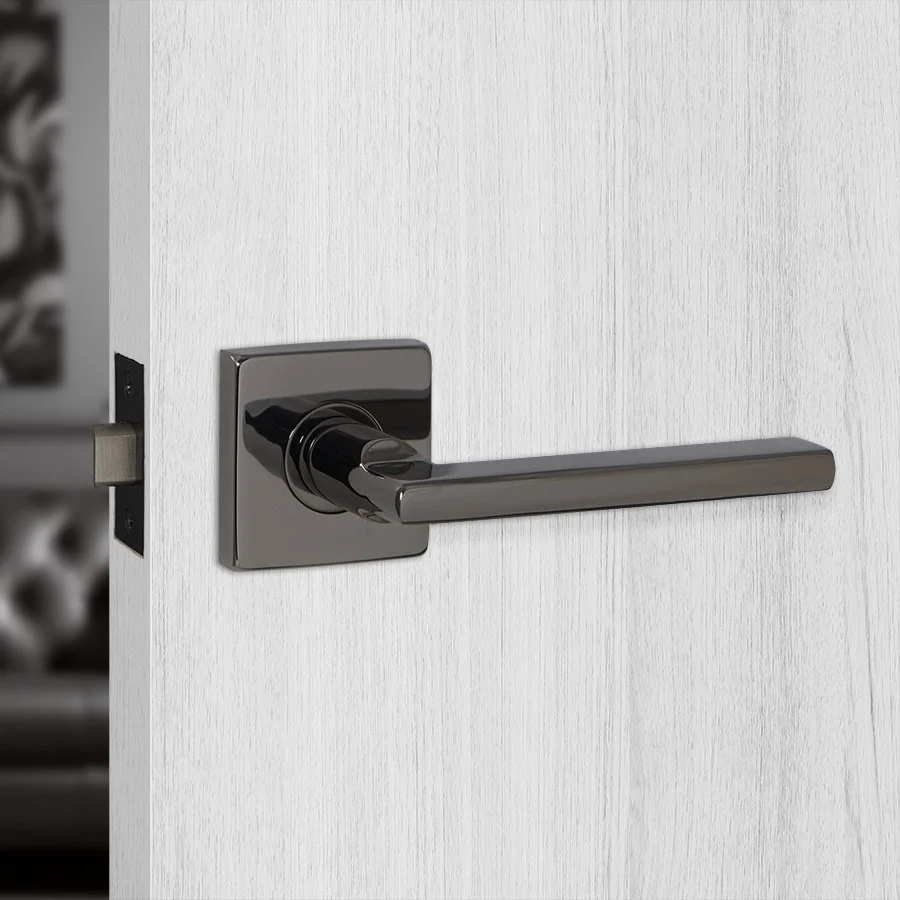 Close-up of a modern silver door handle on a white wooden door.
