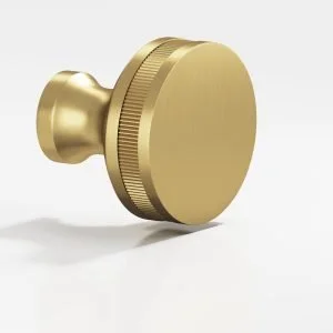 A round, gold-colored object with a knurled edge and a protruding attachment, resembling a large, decorative button or a metal knob.