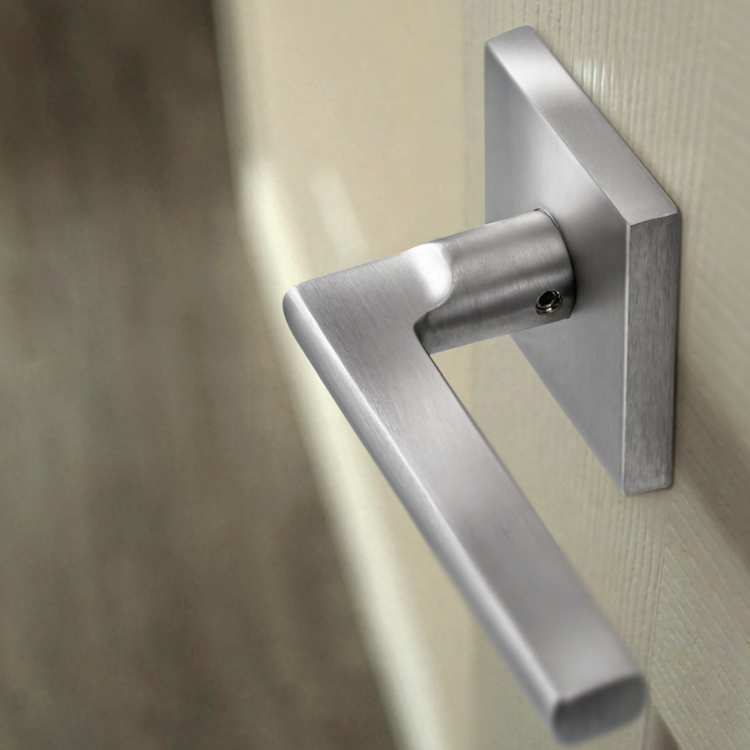 Close-up of a modern silver door handle attached to a door.