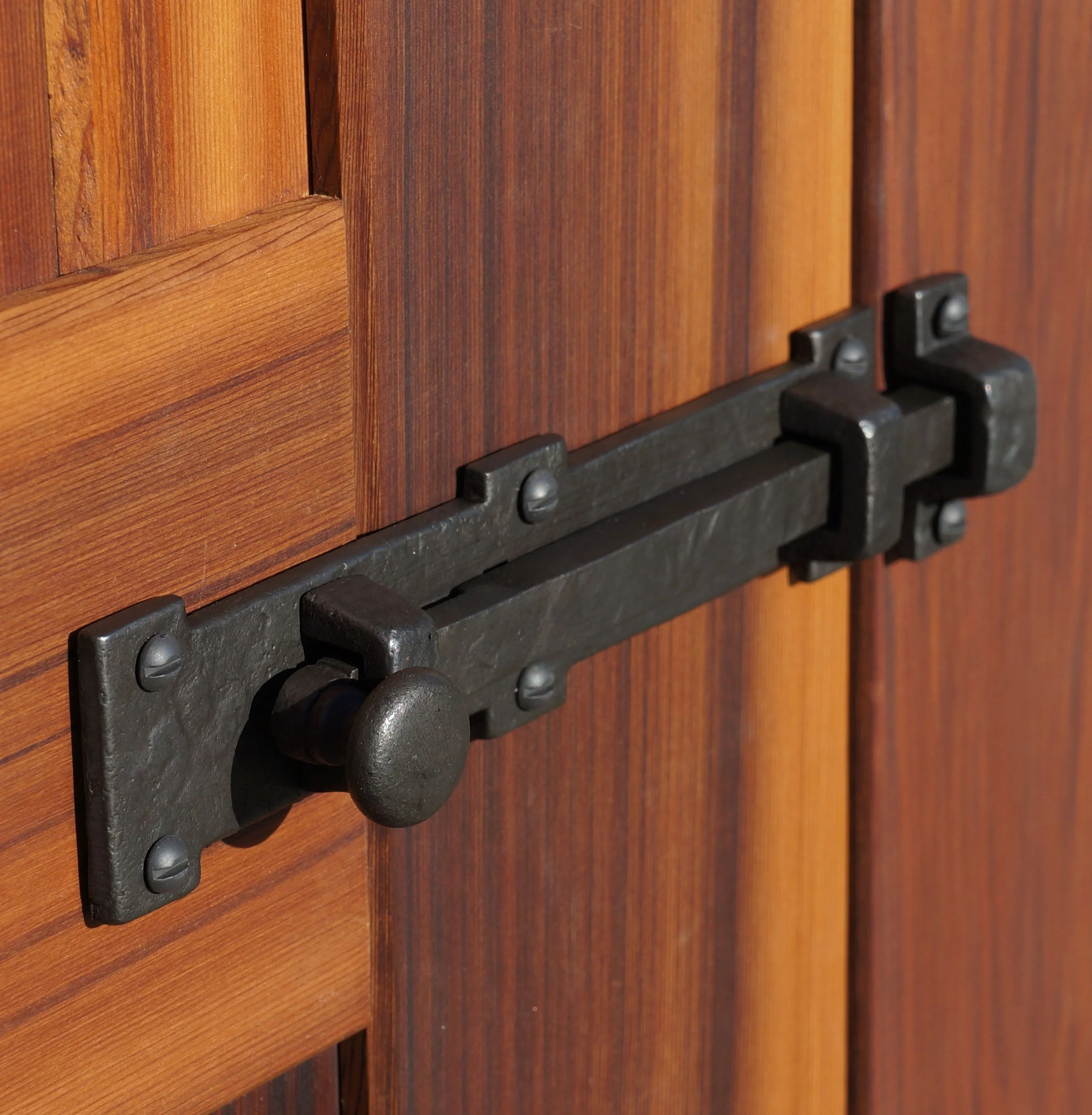 Close-up of a wooden cabinet door with a metal latch.