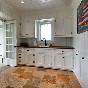 Kitchen with white cabinets, a window above the sink, a black faucet, and a colorful American flag-themed picture on the wall.