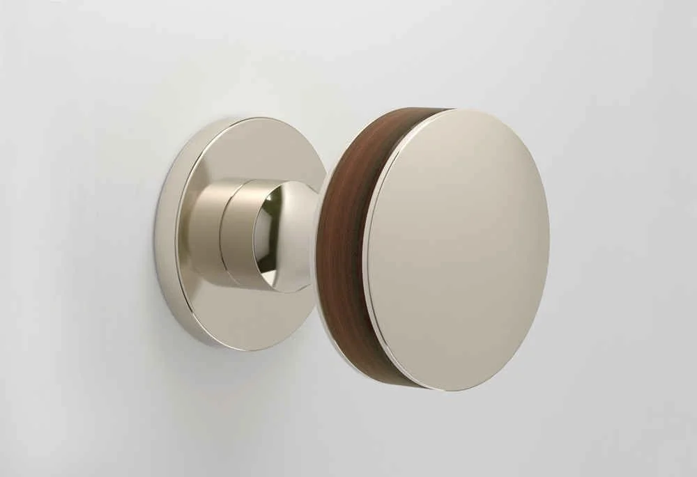 Modern wall-mounted cabinet with a round door, beige and brown finish, on a white wall.