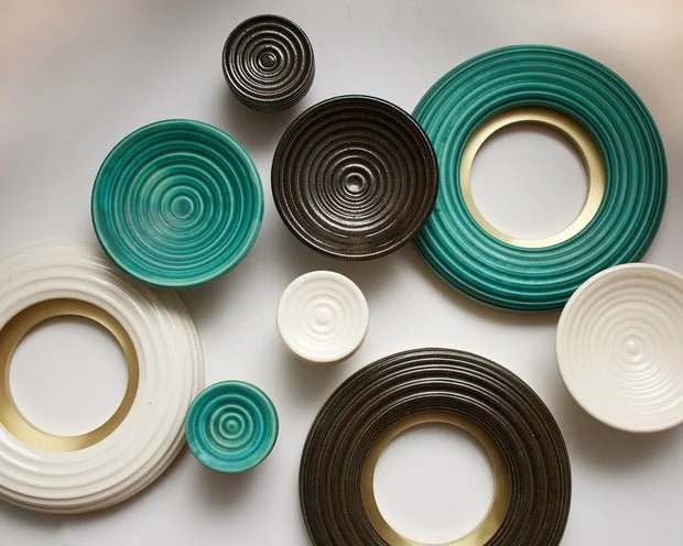 Collection of black, white, and green circular objects with concentric circle patterns on a white surface.