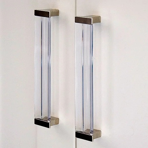 Two vertical glass tubes mounted on a white wall with metallic end caps.