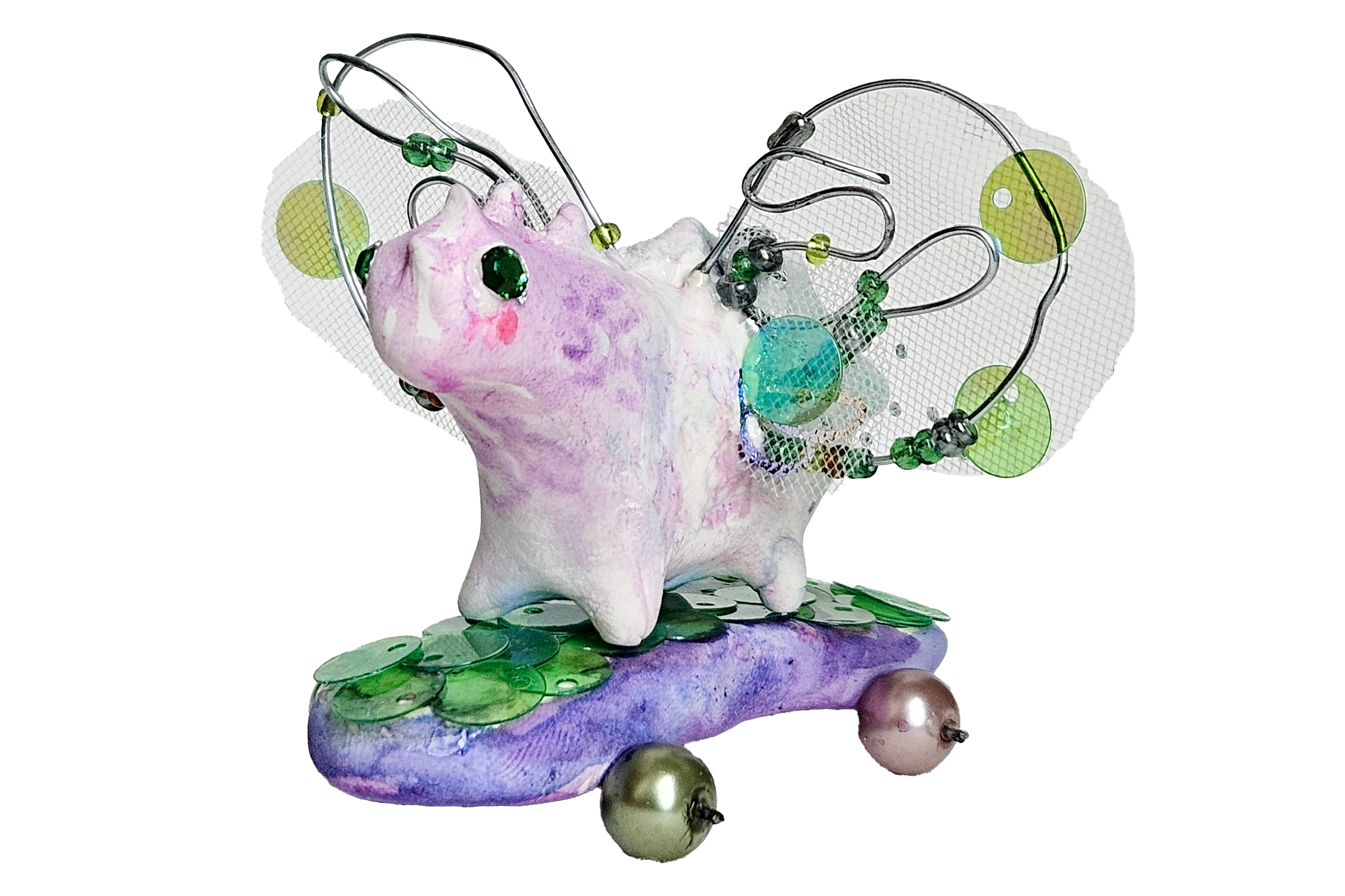 A colorful sculpture of a pig with various metallic and plastic elements, including wires, beads, and discs, attached to its body, standing on a purple and green base.