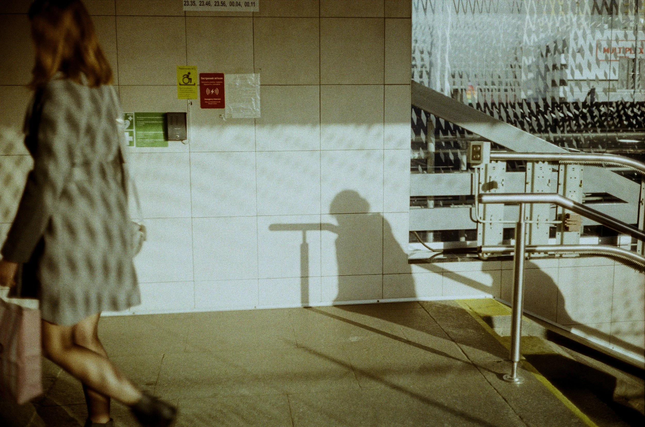 film photo of some walking with a shadow across the wall
