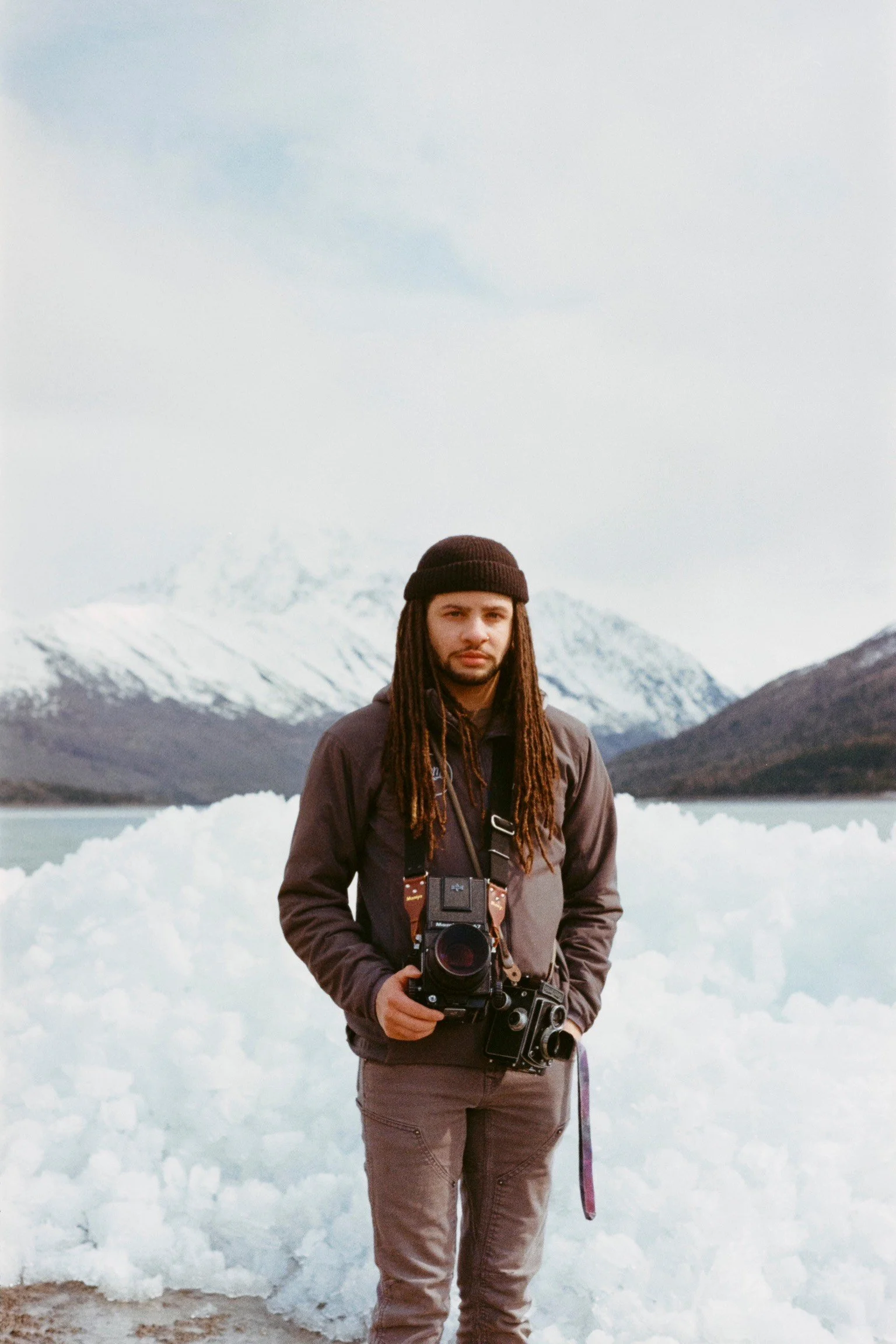 photo of artist and owner of MEDIAM Film Lab Kahleal Milner in front of mountains