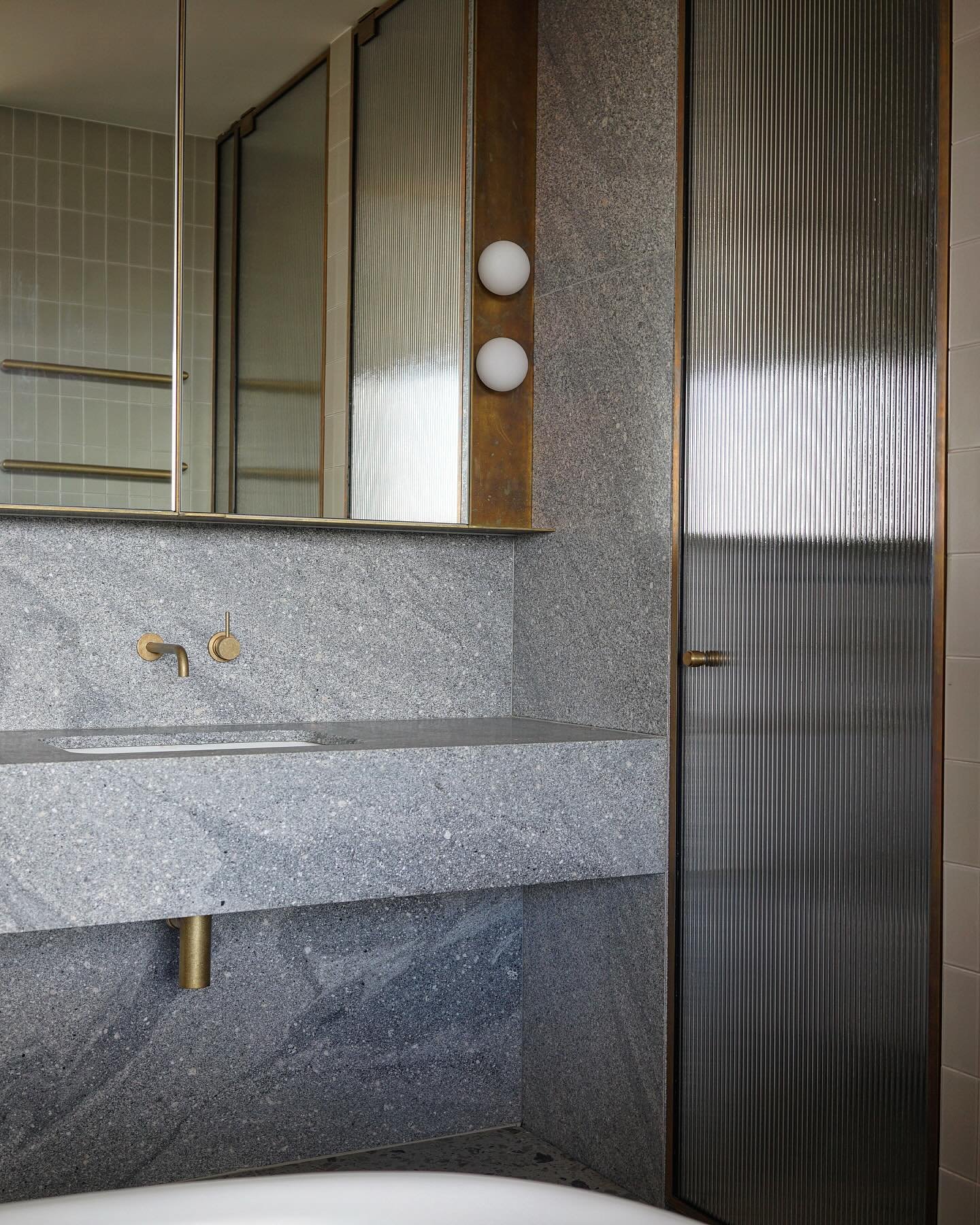Bathroom vignette. A simple palette of grey granite, terrazzo and brass accents.

Architecture &amp; Interiors @studio_kaaki 
Furniture &amp; Styling @studio_kaaki 
Builder @bellevardeconstructions 
Landscape Architect @even_spaces 
Structural Engine