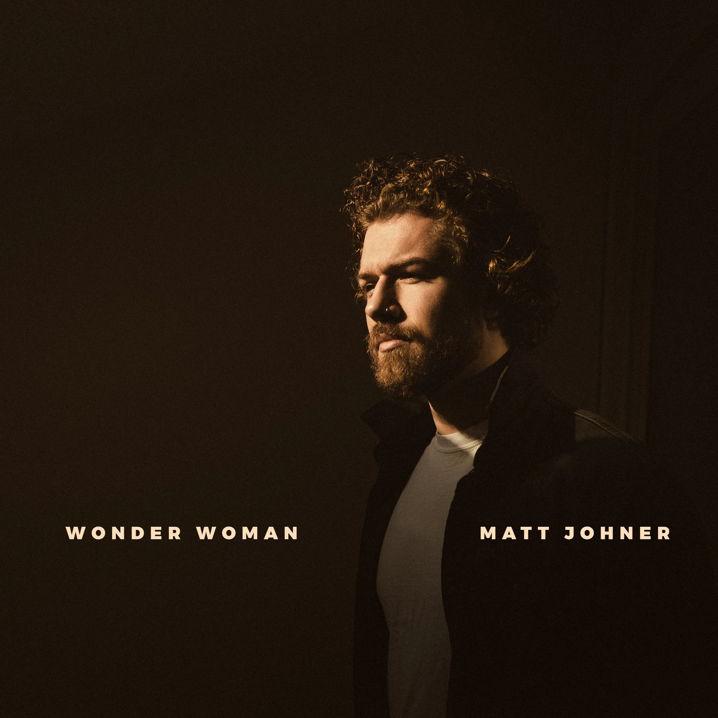 Close-up of a person's face with curly hair, looking to the side, with dark background. Text at the bottom reads 'Wonder Woman' and 'Matt Johner'.