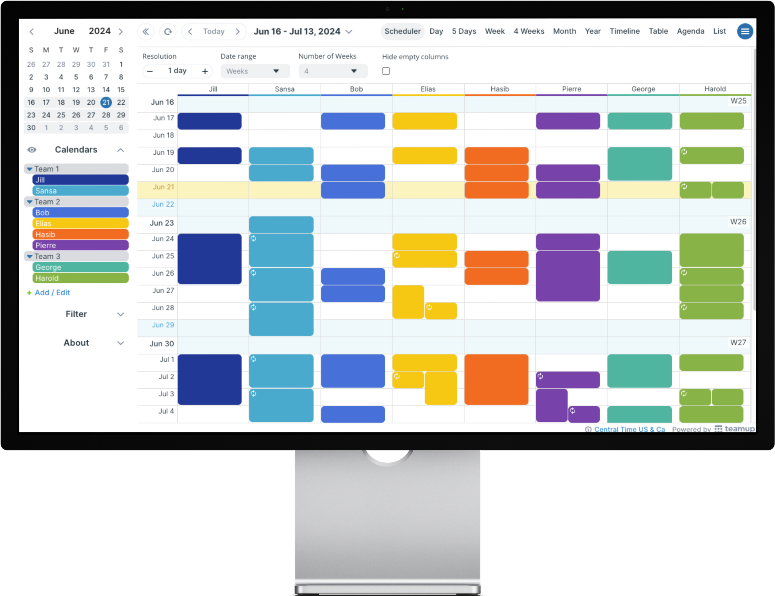 A computer monitor displays a digital schedule or calendar with color-coded events spanning from June 16 to July 13, 2024, showing various scheduled tasks and appointments for different team members.
