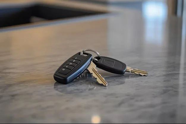 Car keys and remote fob on a gray countertop.
