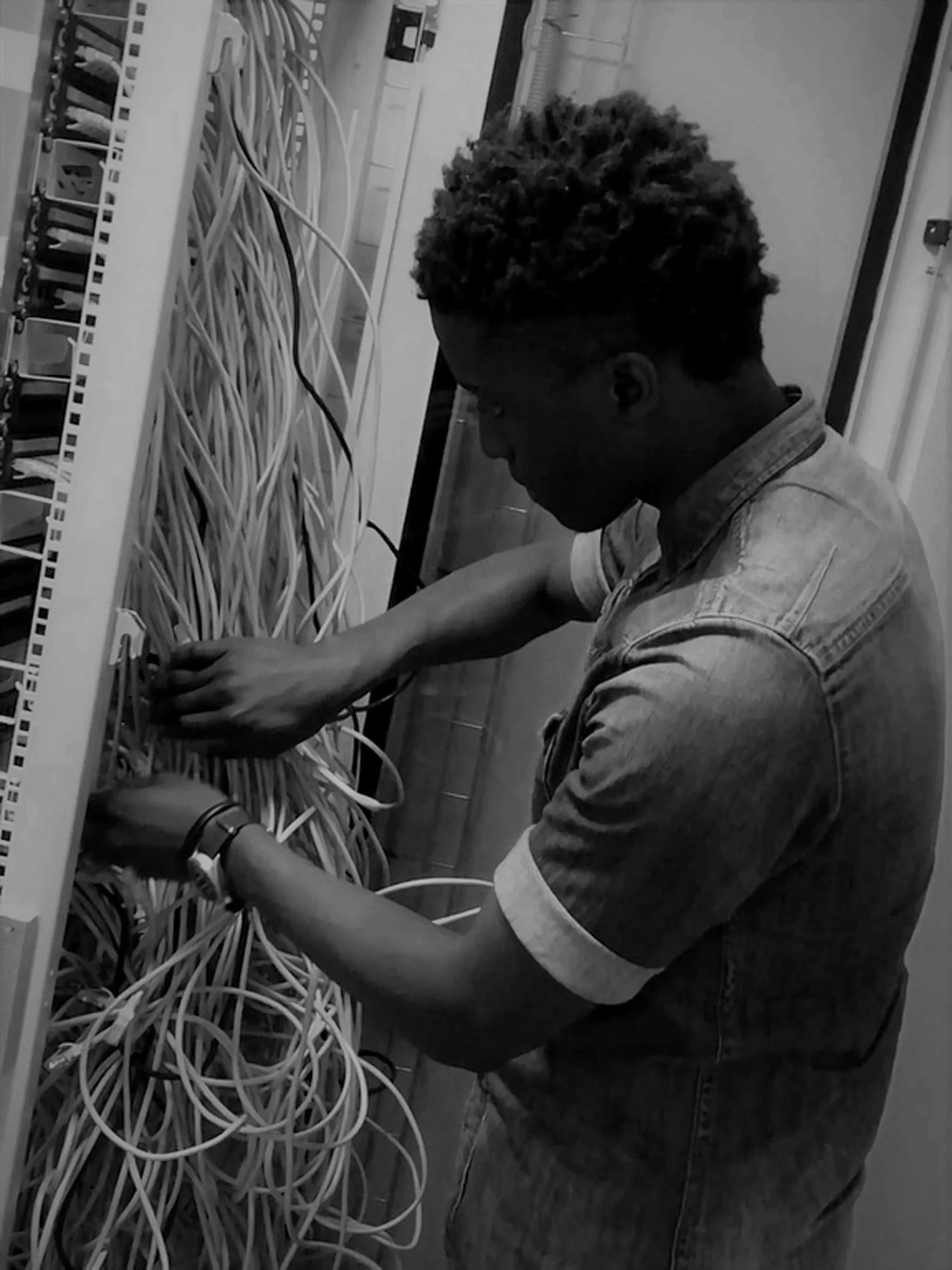 Network technician troubleshooting and organising server rack cabling