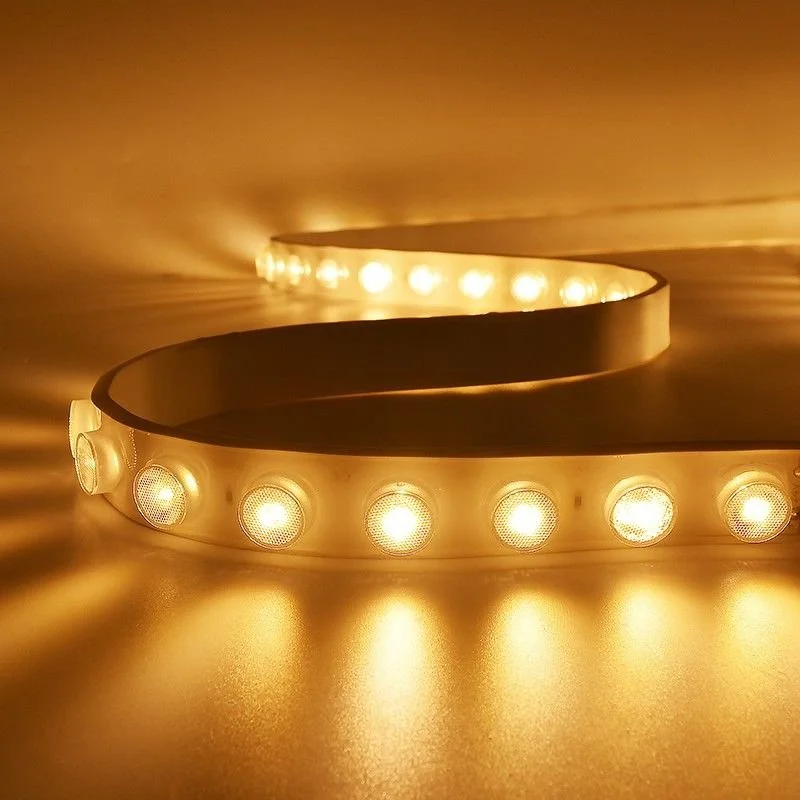 Close-up of a vintage marquee light strip with warm yellow bulbs, coiled on a surface.